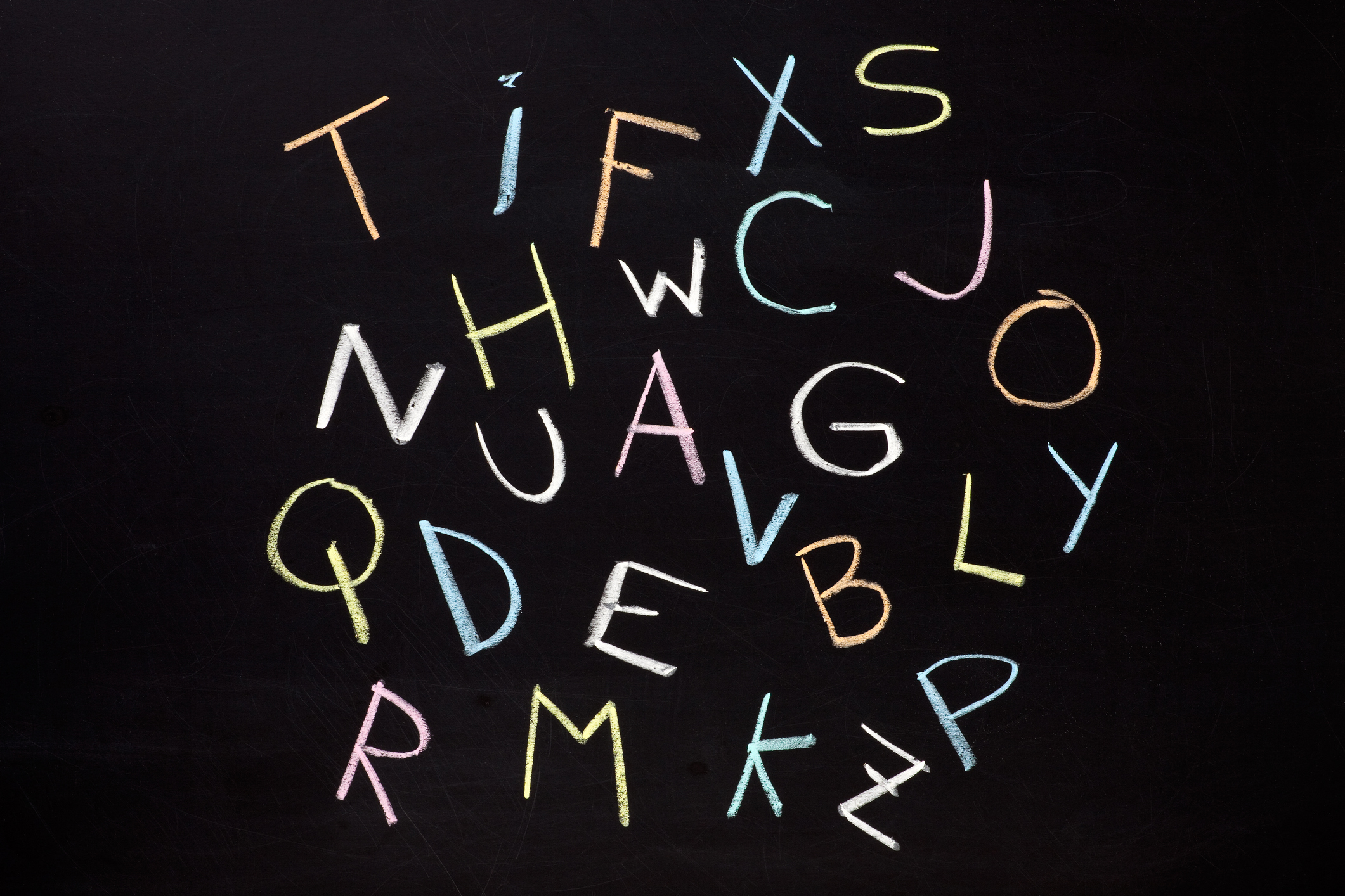 The letters of the alphabet drawn in blackboard without any particular order