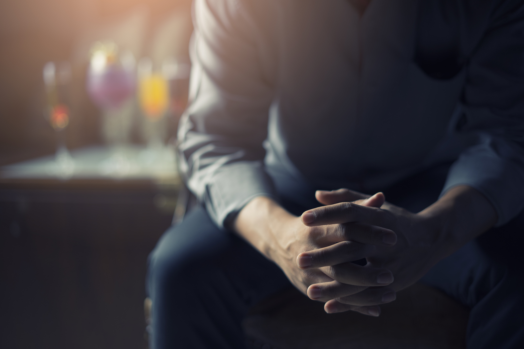 very Tired or stressed businessman hand touching head and sitting in front of cocktail and alcohol drink with darken mood and tone filter business concept and health concept