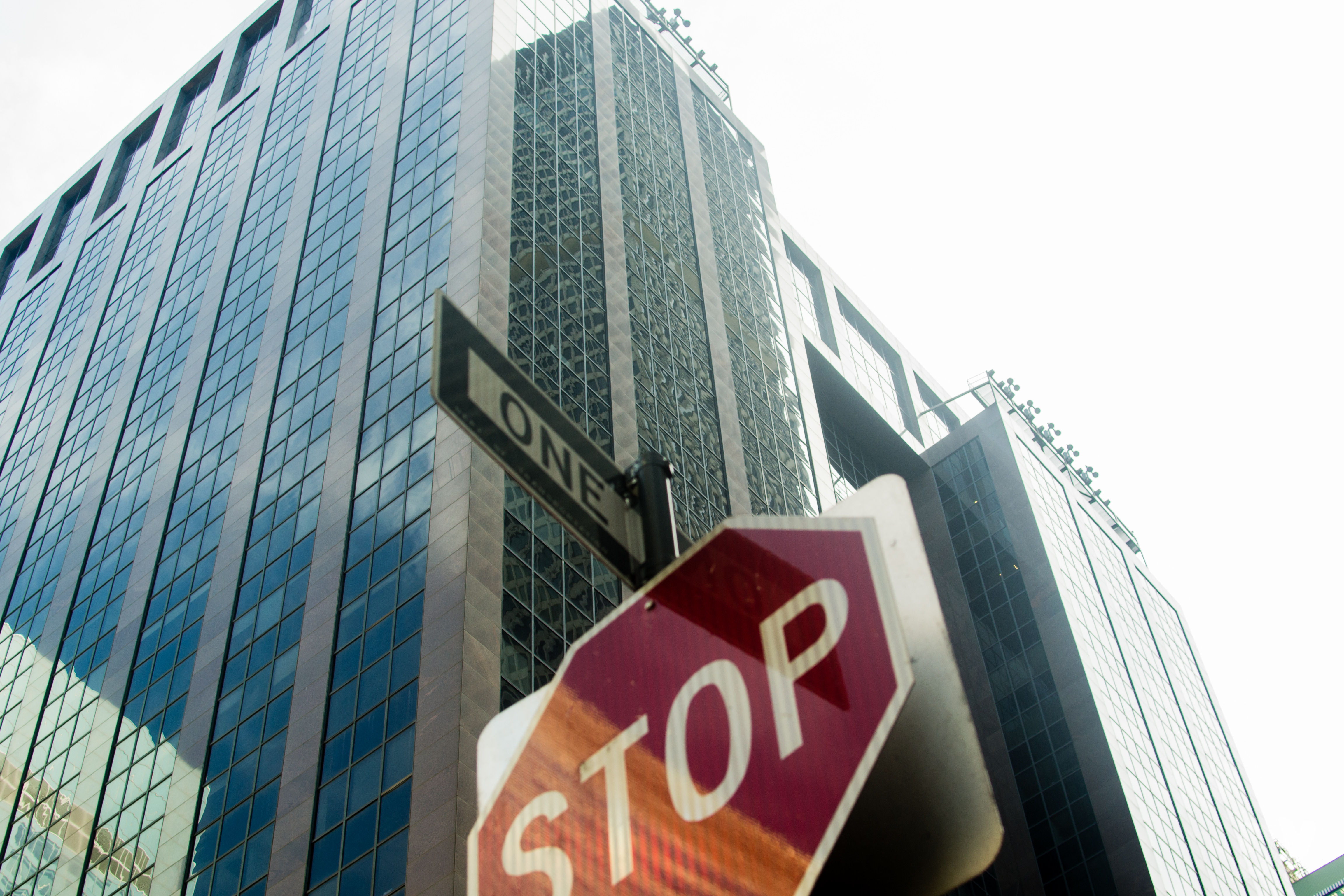 Perspective of a person looking up at a stop sign with skyscrapers in the background