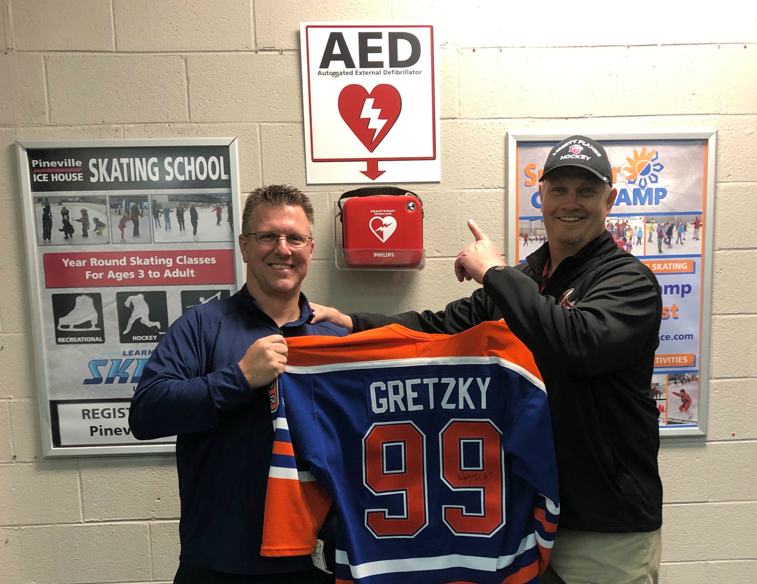 Jib Street (right) and Dr. Craig Bryant at the Pineville Ice House. The signed Wayne Gretzky jersey was Jib&#039;s thank-you gift to Craig for using the AED to save his life. (Photo courtesy of Jib Street)