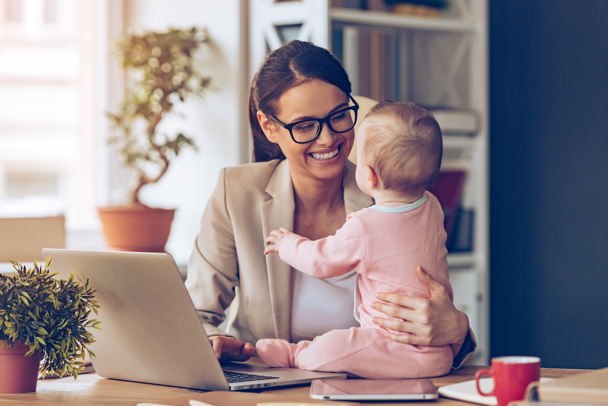 A working mom interacts with her baby on her desk
