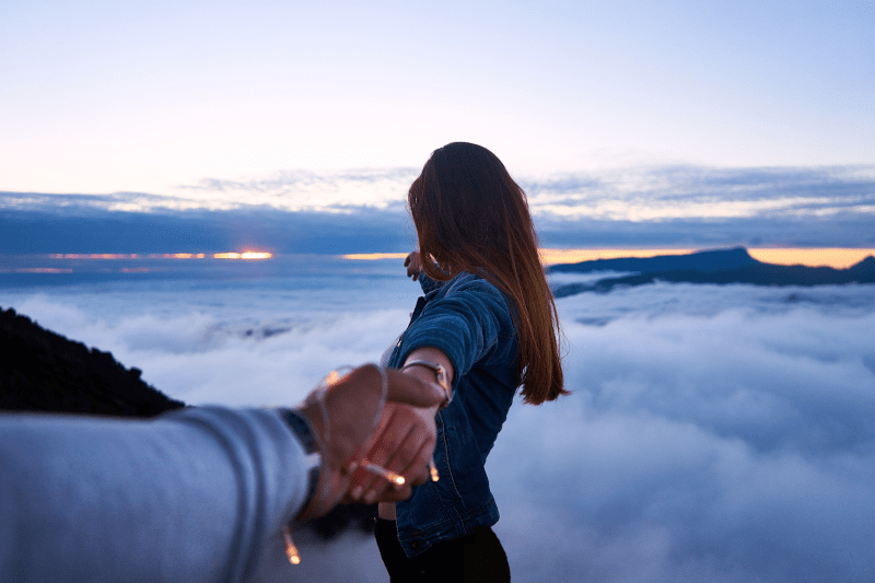 Woman showing the horizon to a man holding his hand, man POV | 3 Important Lessons Men in Midlife Can Learn from Women