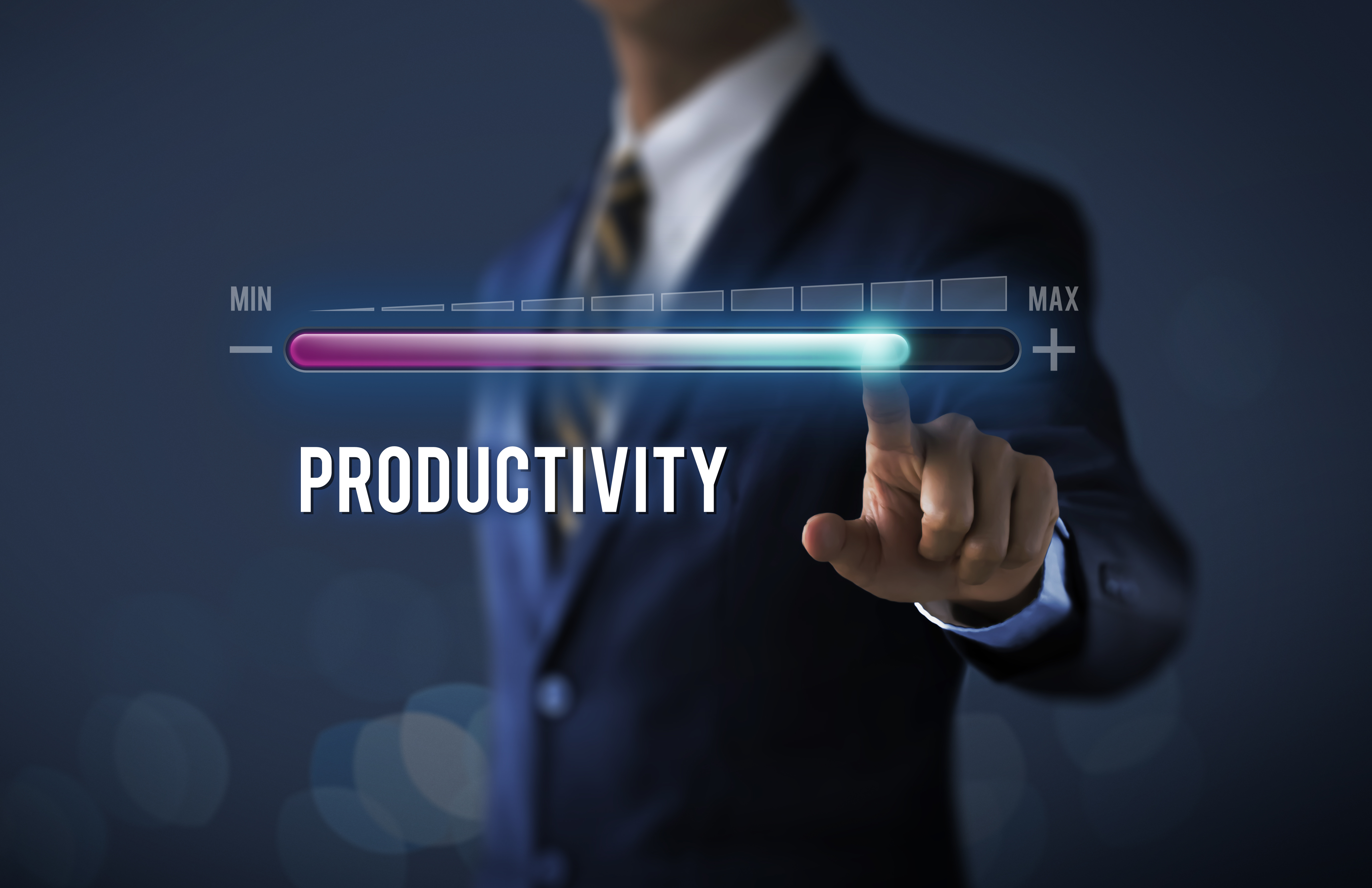 Increase productivity concept. Businessman is pulling up progress bar with the word PRODUCTIVITY on dark tone background.