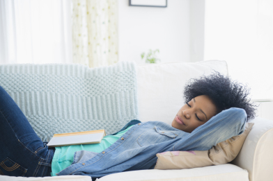 African American woman napping on sofa