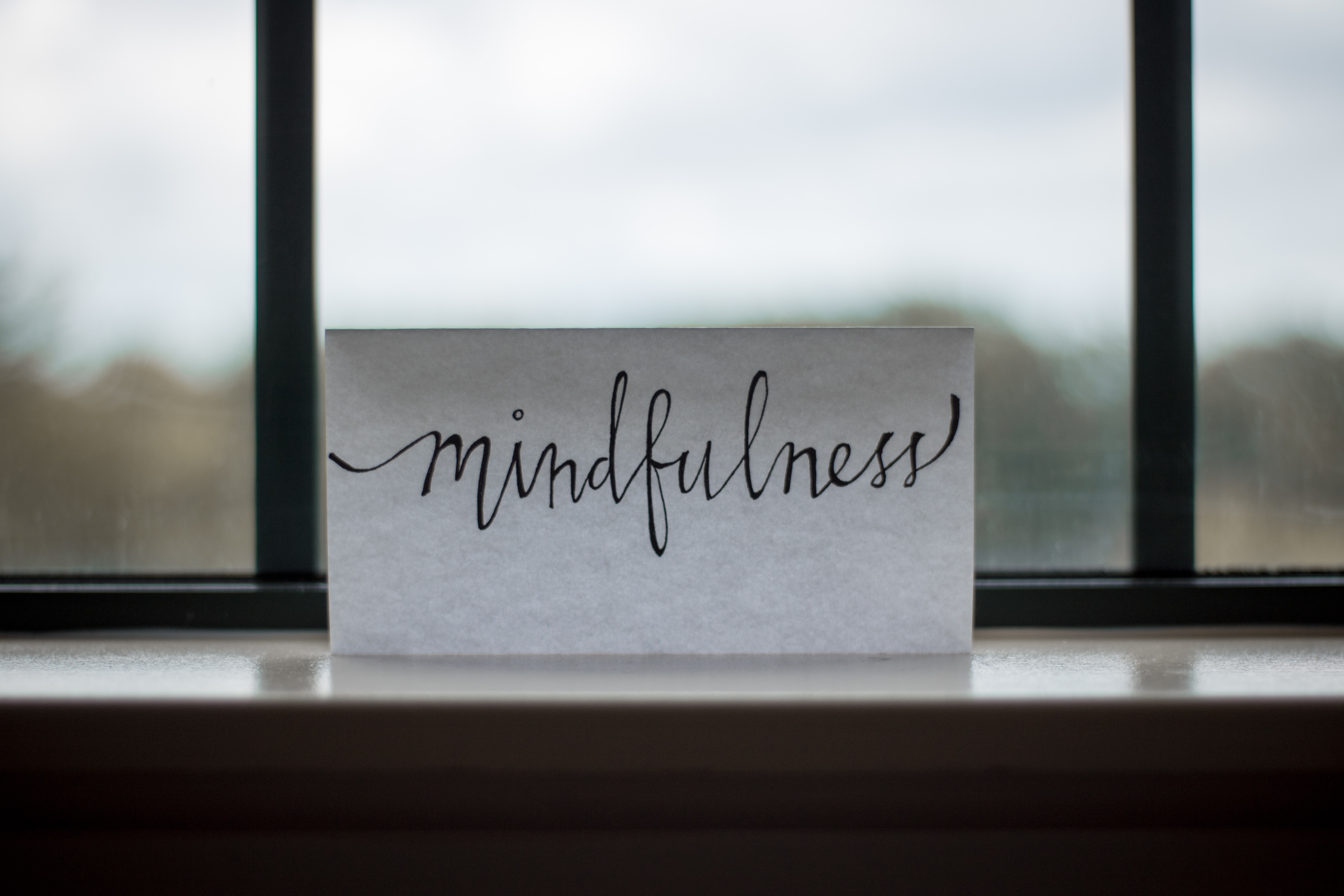 &quot;Mindfulness&quot; wrritten on white paper, standing on the window ledge