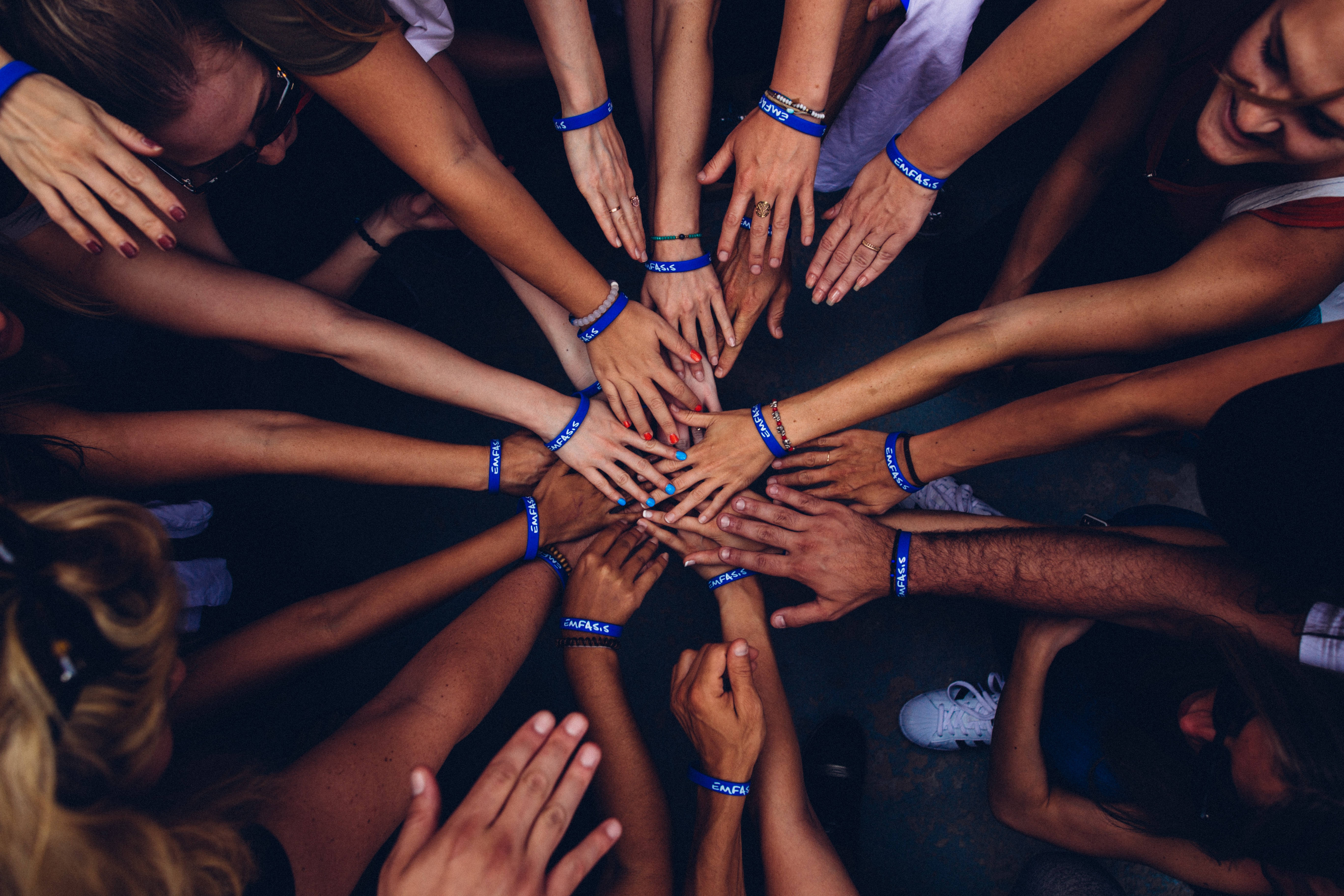 Team members in a circle with hands on top of each other