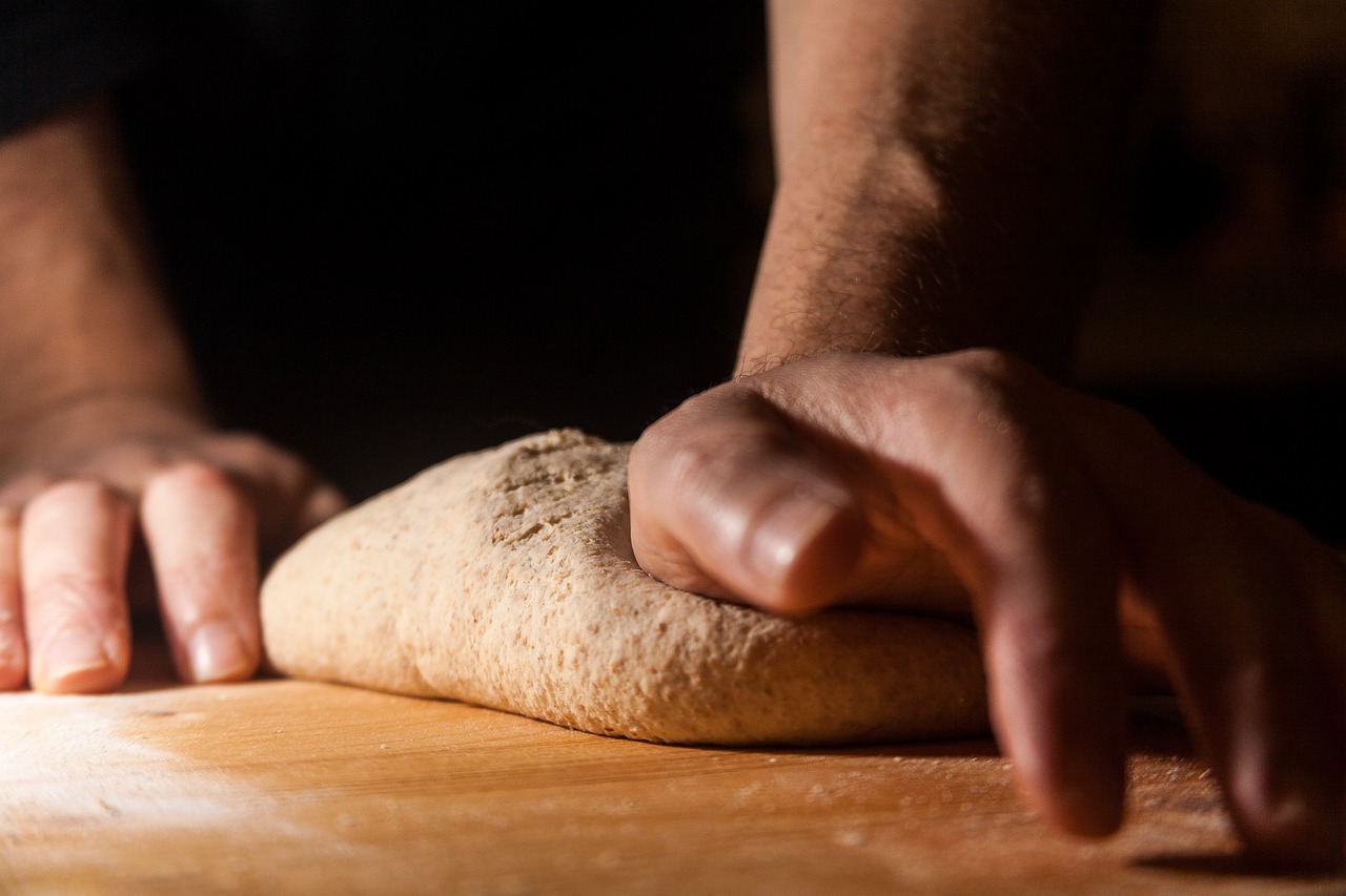 Hands of a man kneading a dough
