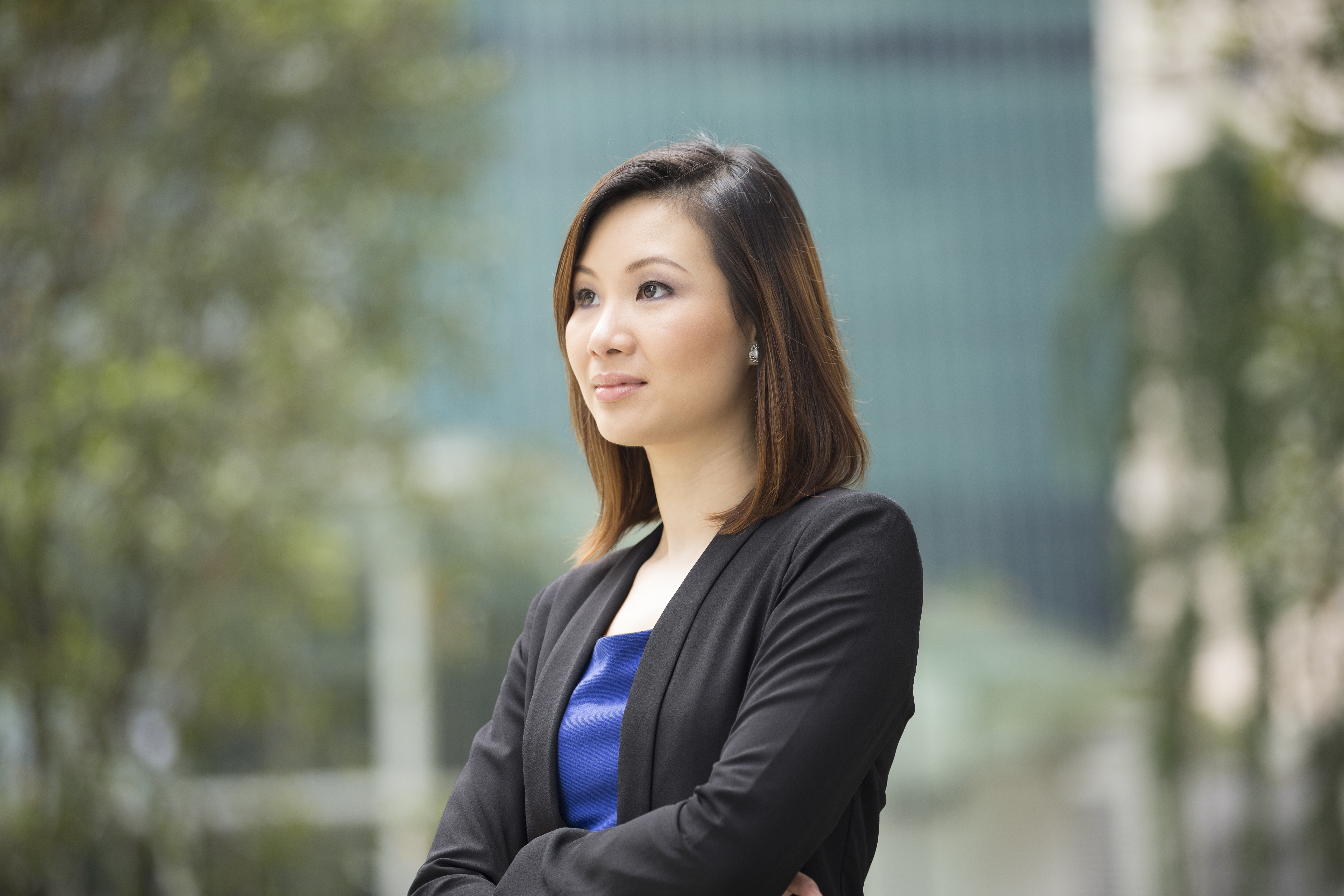 Portrait of thoughtful Chinese businesswoman looking away. Asian business woman in smart business suitstanding outside in modern city.