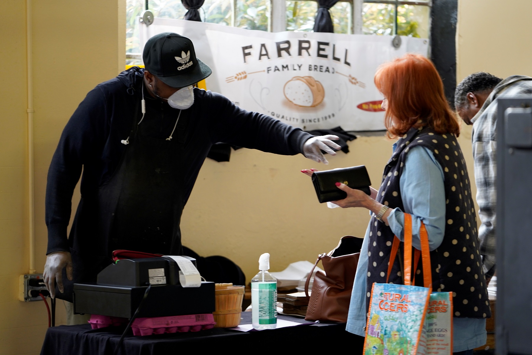 Vendor Cedric McIver gives change back to a customer at the Farmers Public Market in Oklahoma City, Oklahoma, U.S., March 21, 2020. Picture taken March 21, 2020. REUTERS/Nick Oxford