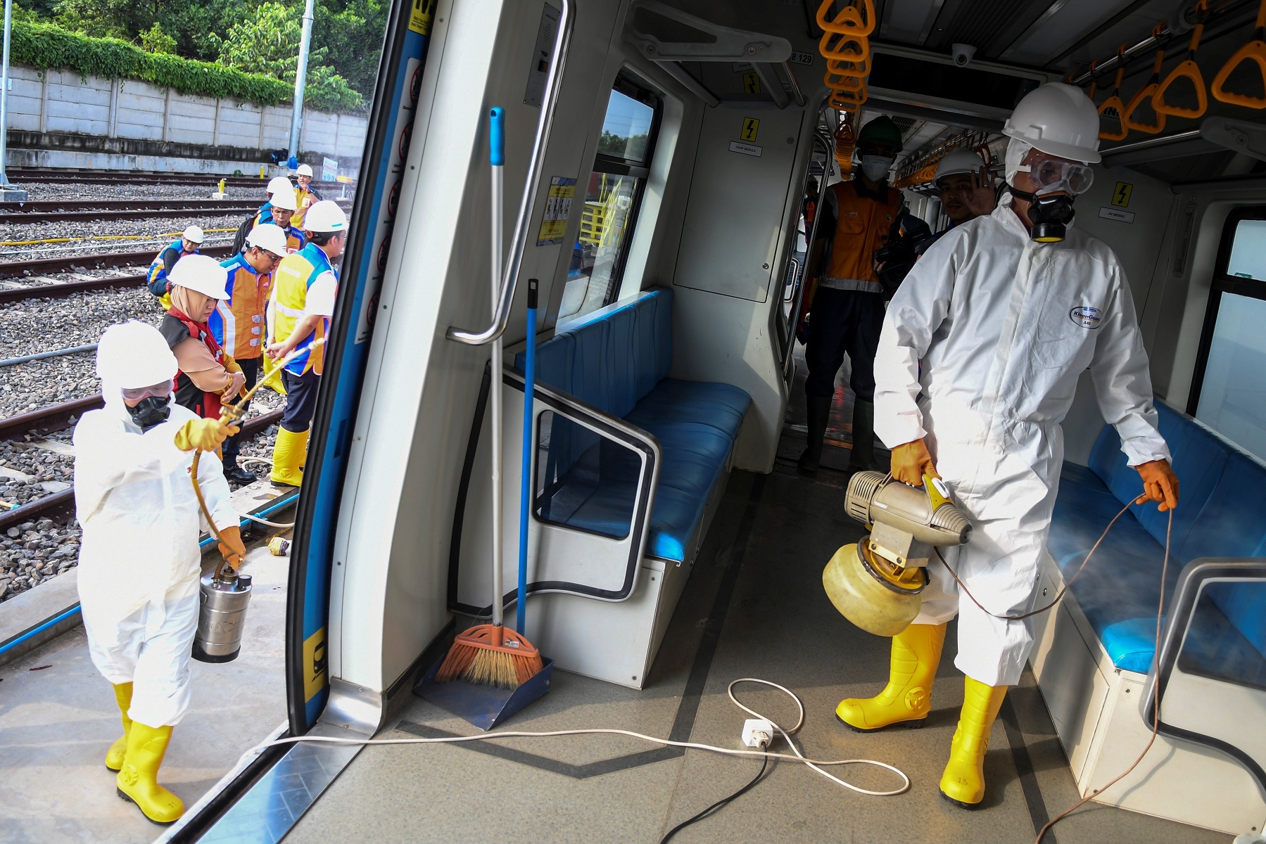 Staff in protective suits spray disinfectant on the Light Rail Transit (LRT) train after Indonesia confirmed new cases of coronavirus disease (COVID-19), in Palembang, South Sumatra, Indonesia  March 10, 2020 in this photo taken by Antara Foto.  Antara Foto/NovaWahyudi/ via REUTERS  ATTENTION EDITORS - THIS IMAGE WAS PROVIDED BY A THIRD PARTY. MANDATORY CREDIT. INDONESIA OUT.
