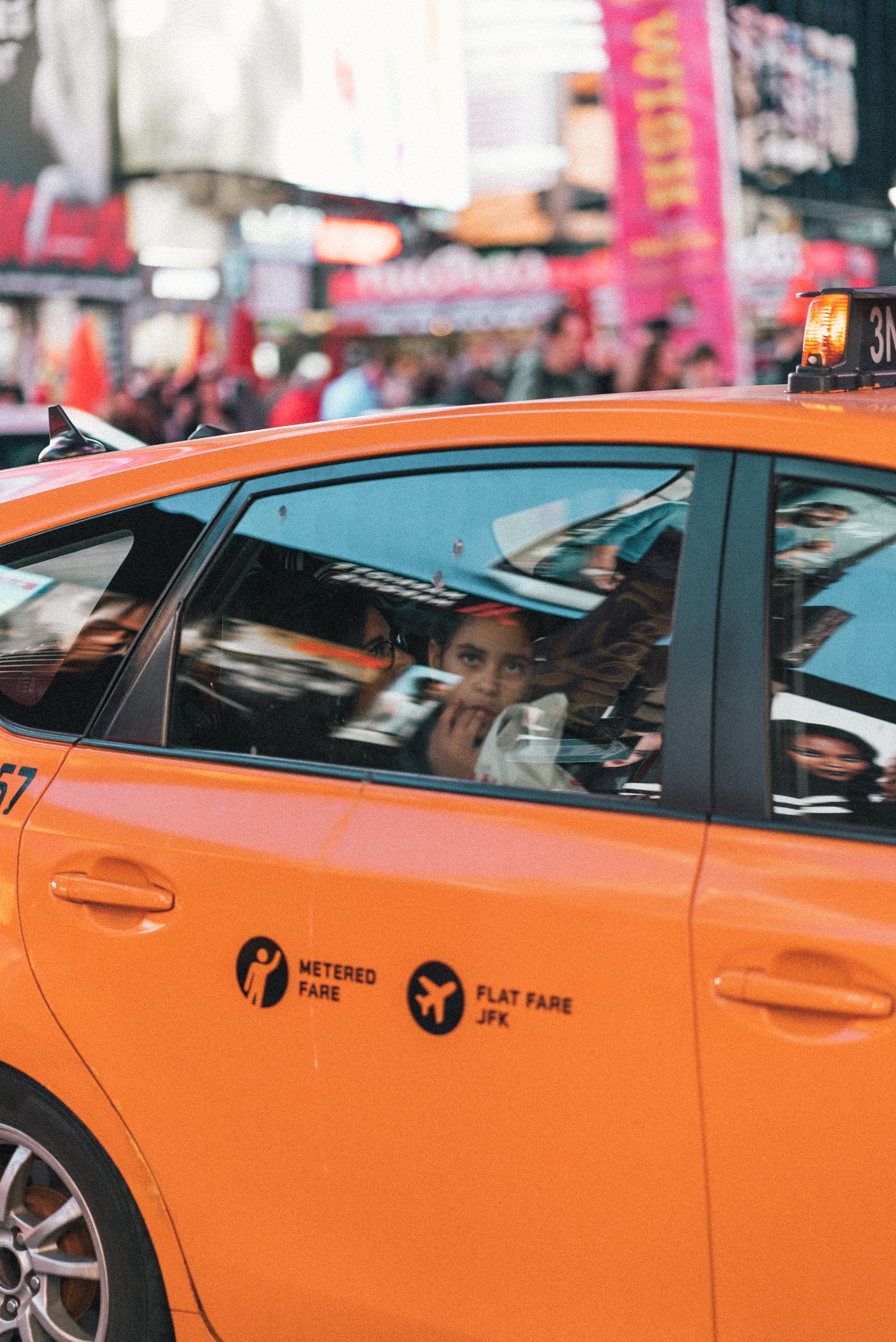 woman leaving in an orange taxi