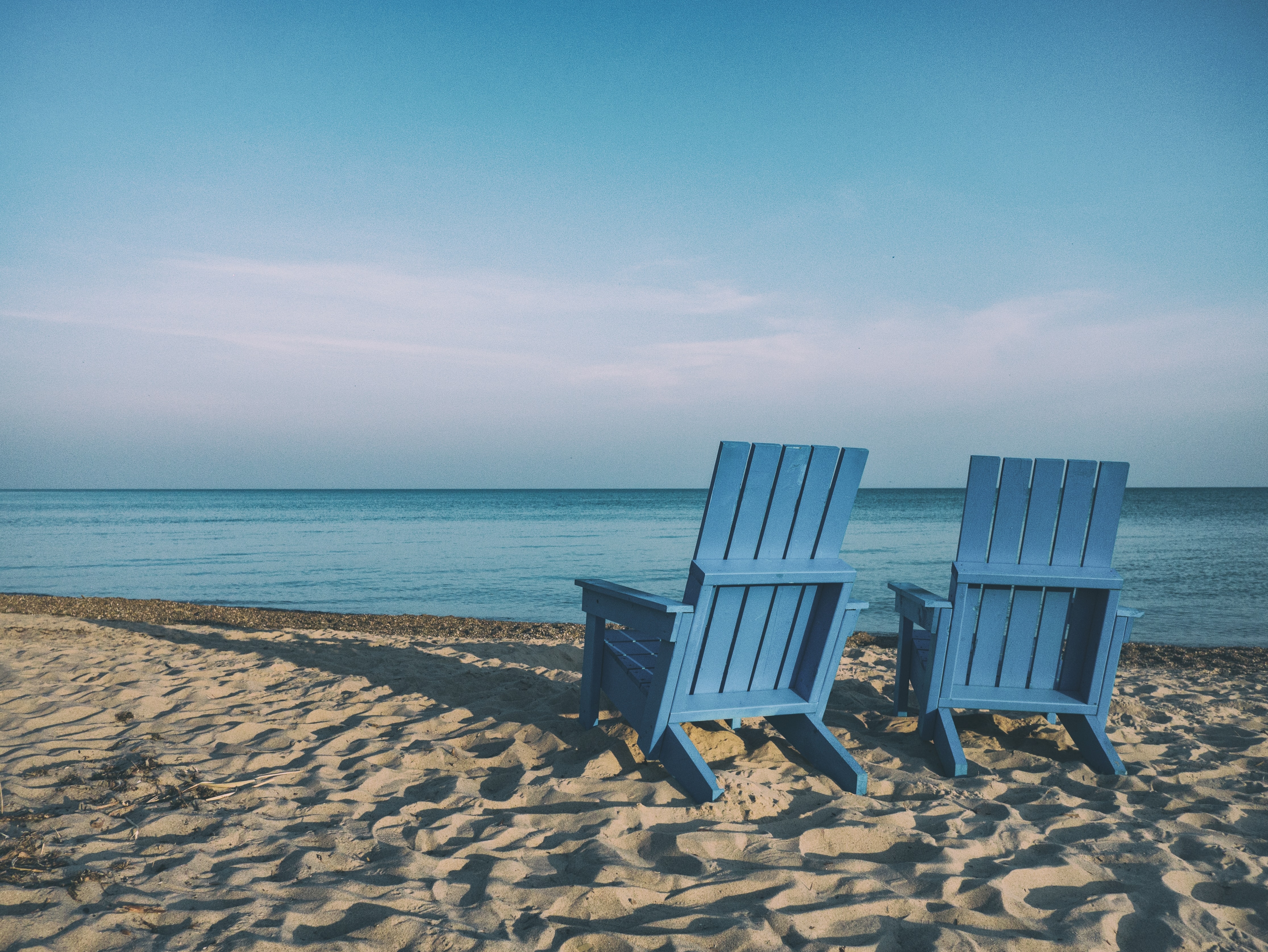 Two blue chairs on a beach