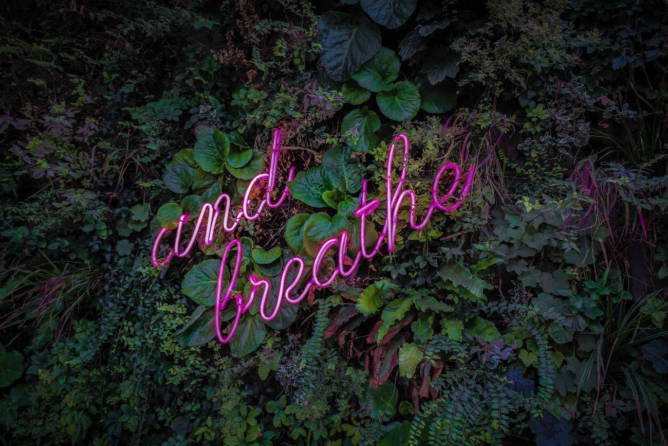 image of neon sign that says And Breathe