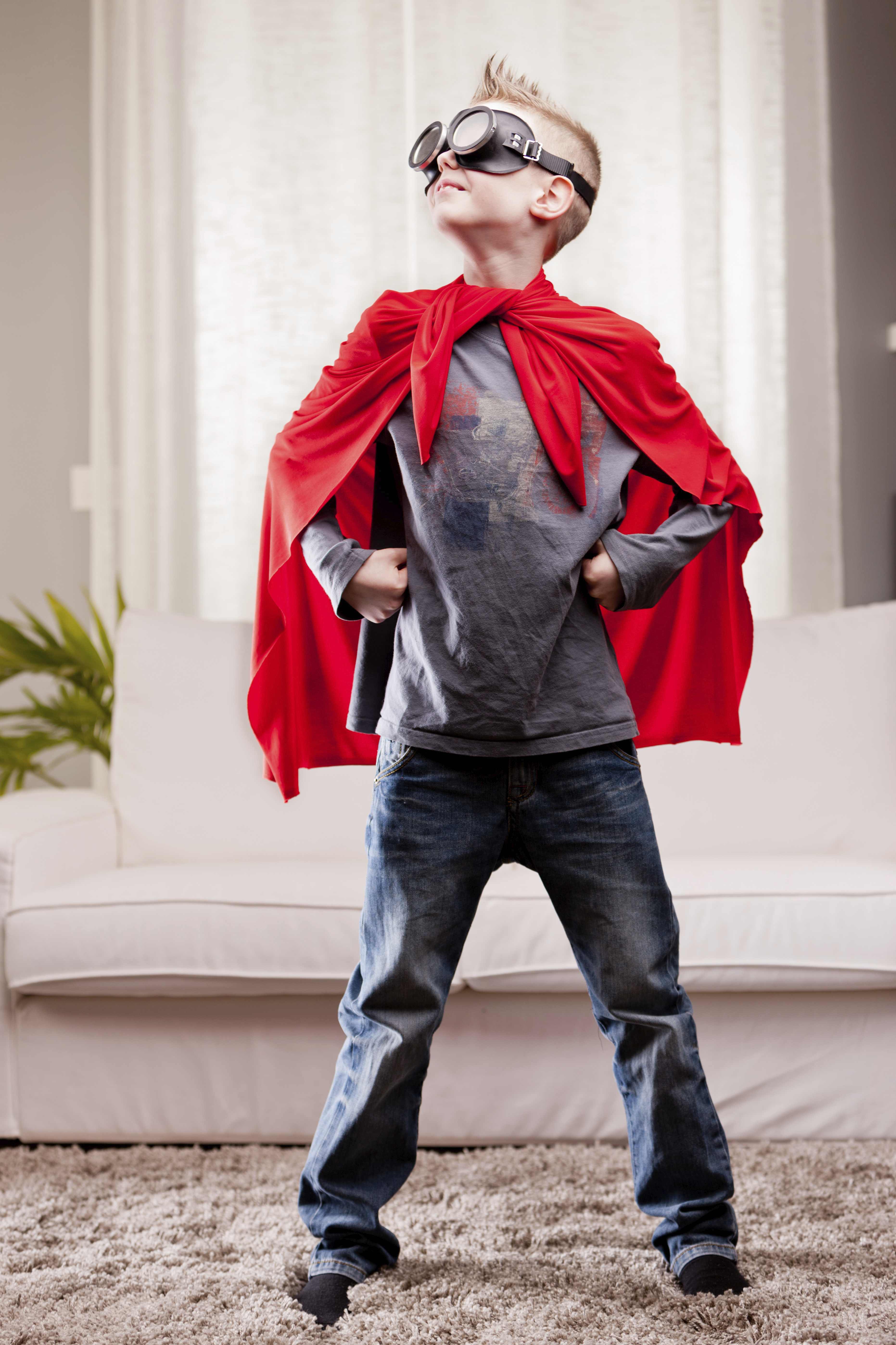 a little kid playing as a red cloak serious superhero