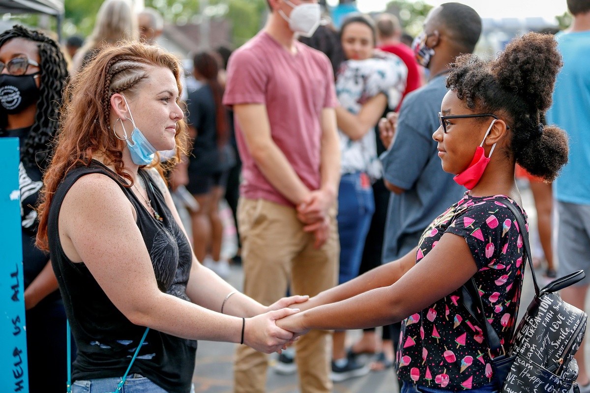 Two women hold hands during a reconciliation revival, part of an event to mark Juneteenth, which commemorates the end of slavery in Texas, two years after the 1863 Emancipation Proclamation freed slaves elsewhere in the United States, amid nationwide protests against racial inequality in Minneapolis, Minnesota, U.S. June 19, 2020. REUTERS/Eric Miller