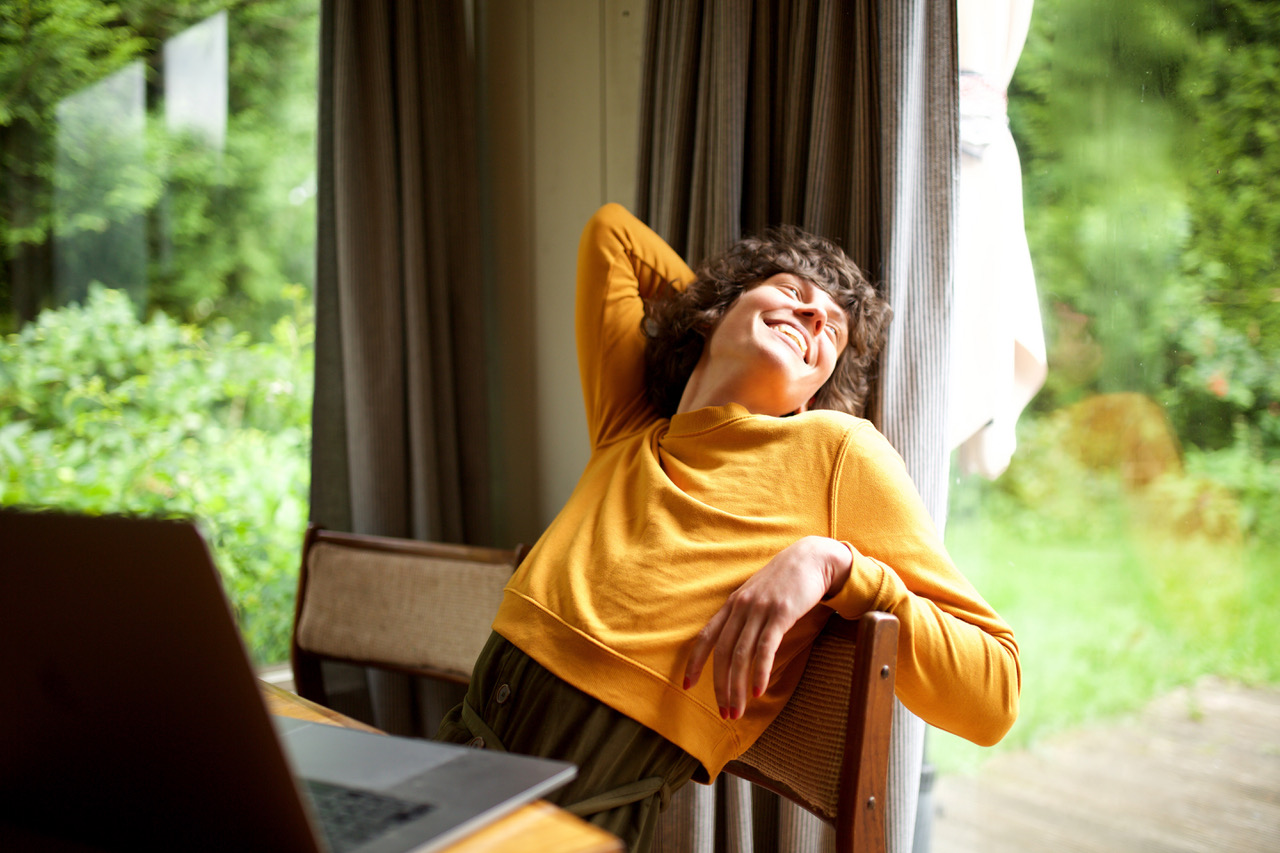 Portrait of woman relaxing at home looking out of window