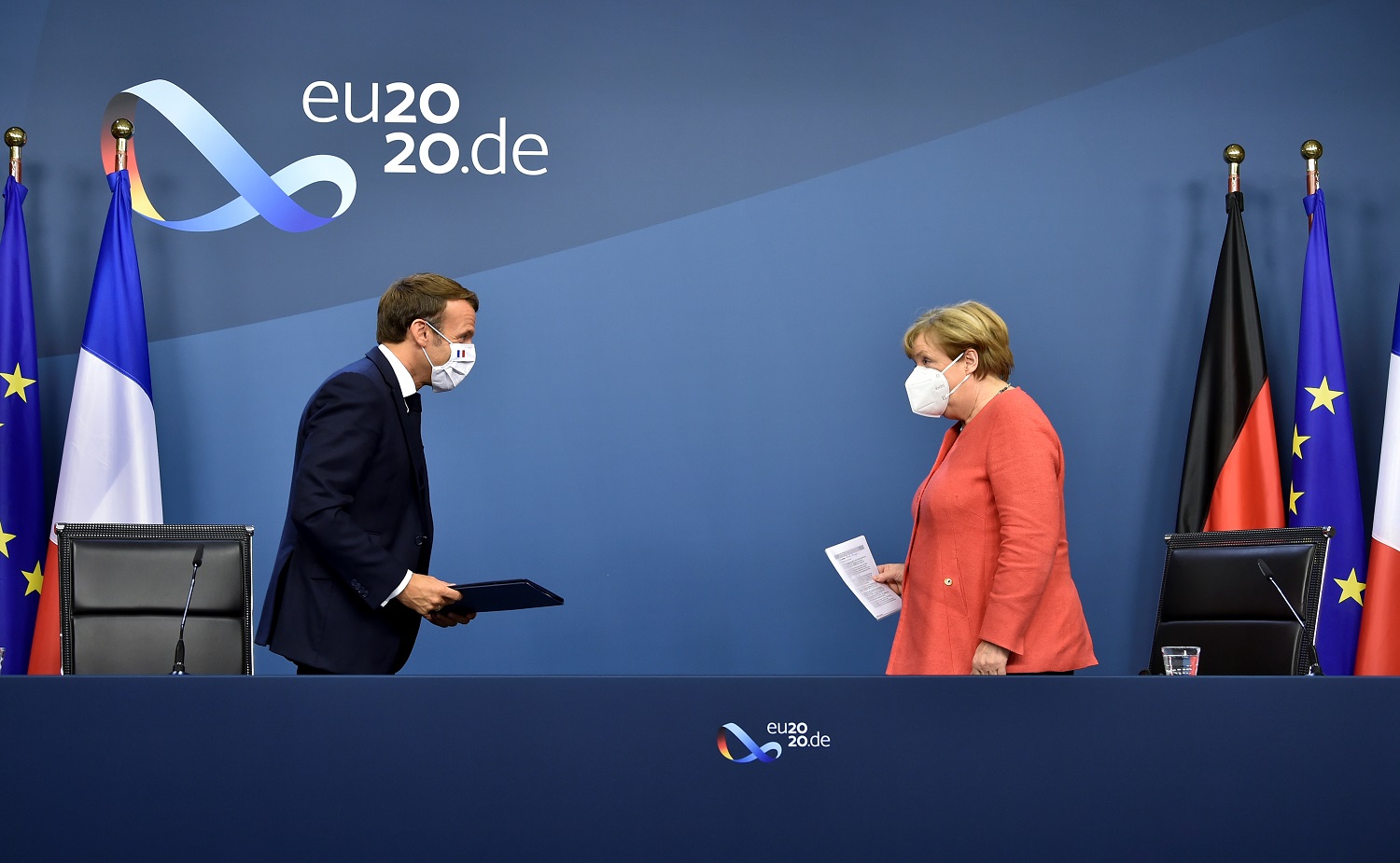 German Chancellor Angela Merkel and French President Emmanuel Macron leave after their joint video press conference at the end of the European summit at the EU headquarters in Brussels, Belgium July 21, 2020. John Thys/Pool via REUTERS