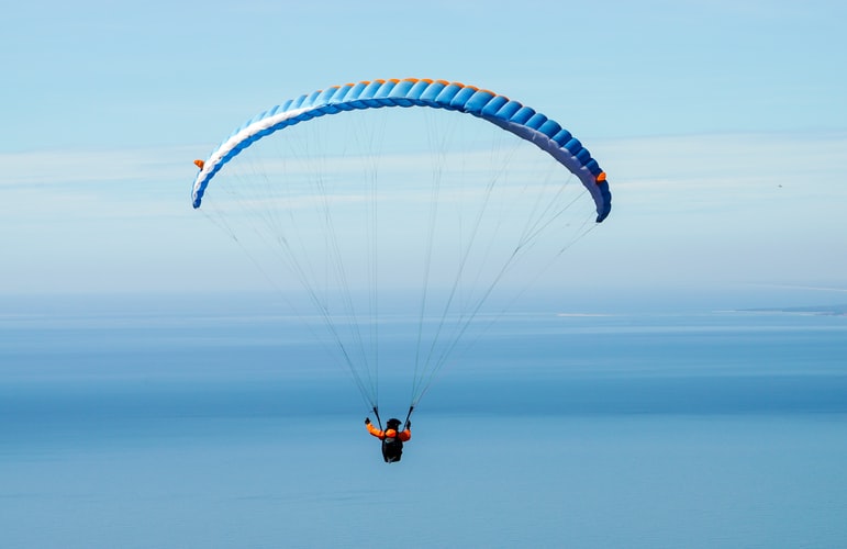A paraglider in the middle of the blue sky