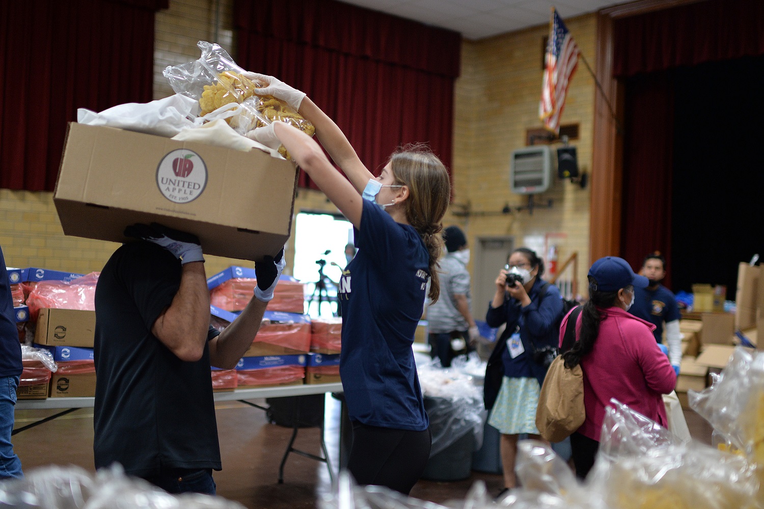 Wearing protective masks and gloves in the time of COVID-19, volunteers help prepare and distribute donated food to people seeking assistance at St. Finbar Catholic Church, in the Brooklyn borough of New York, NY, May 29, 2020. With enough food packages for 1500 individuals, Catholic Charities Brooklyn and Queens distributed food to those suffering from food insecurities caused by the impact of the Coronavirus pandemic and Its effect on the economy. (Anthony Behar/Sipa USA)No Use UK. No Use Germany.