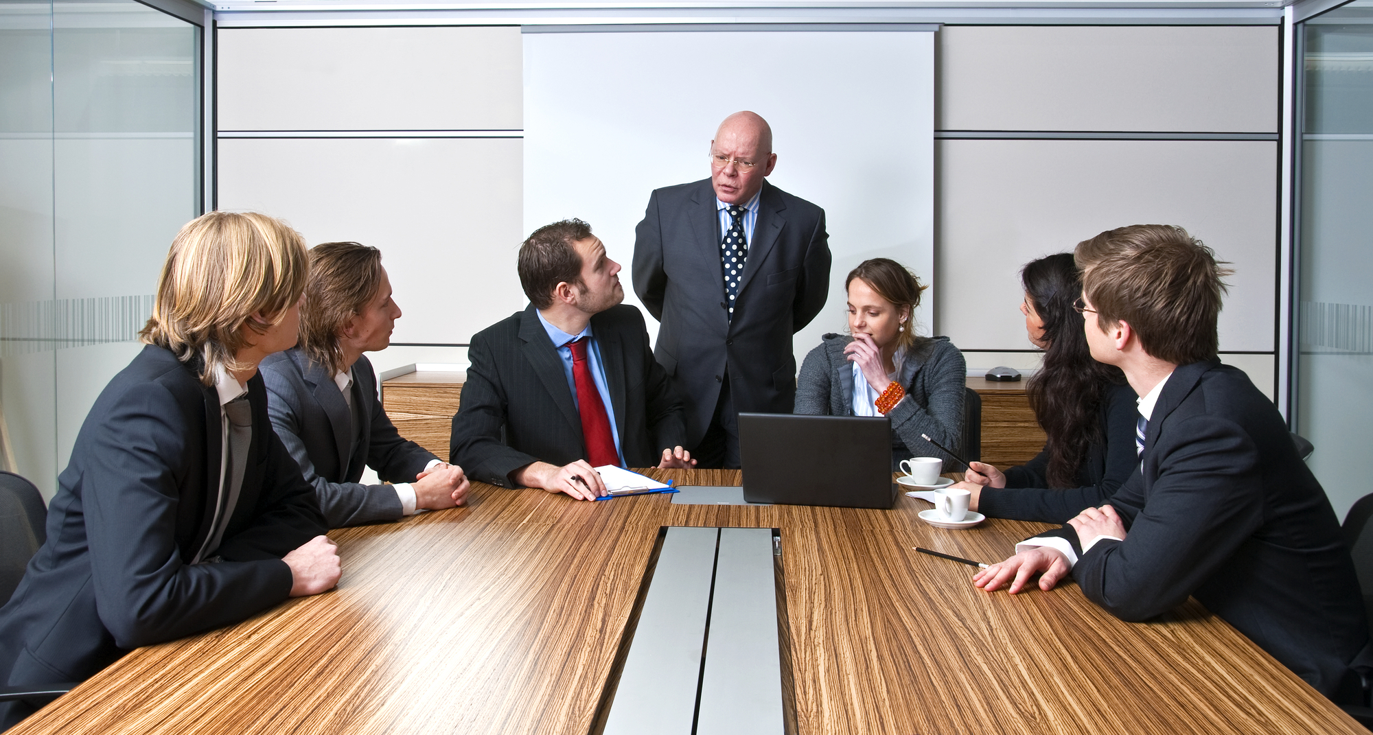 A company manager, and his team, discussing business strategies during an office meeting