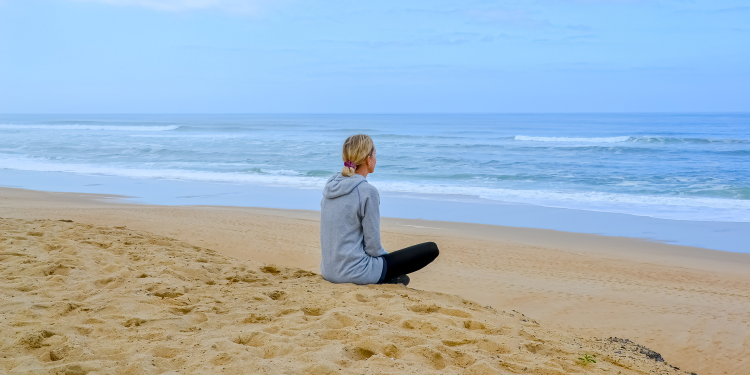 Woman sitting quietly on beach