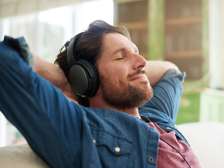 Shot of a man relaxing at home with his headphones on