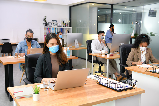 Workers practicing social distance and wearing of masks in the office