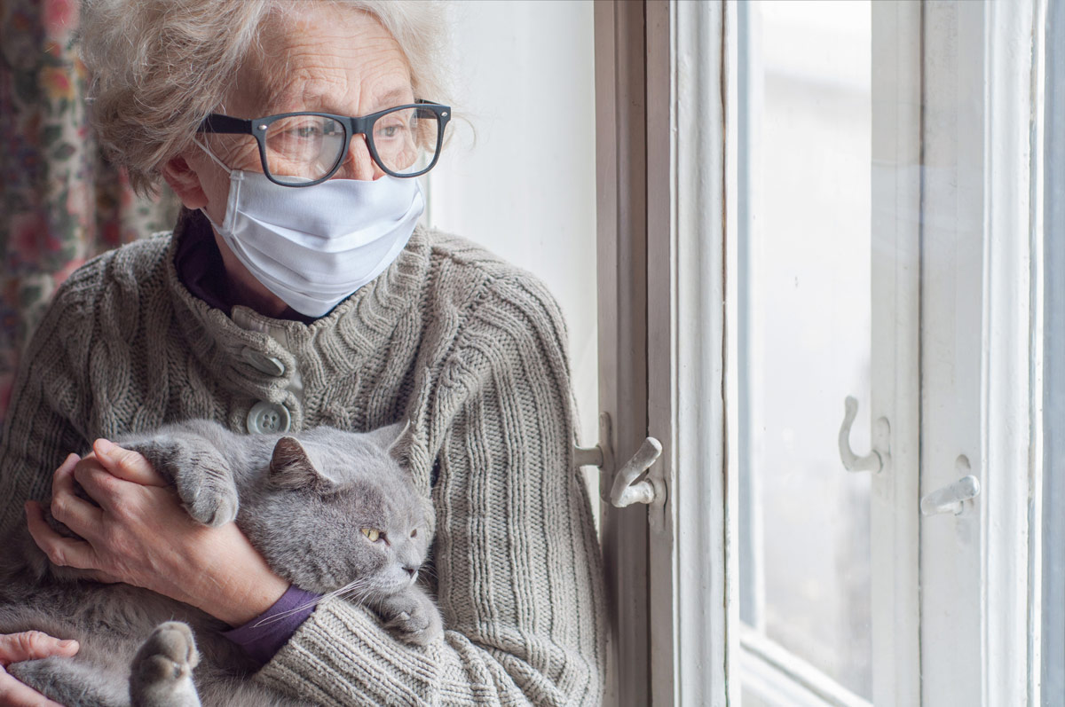 Elder woman and her cat isolated indoors.