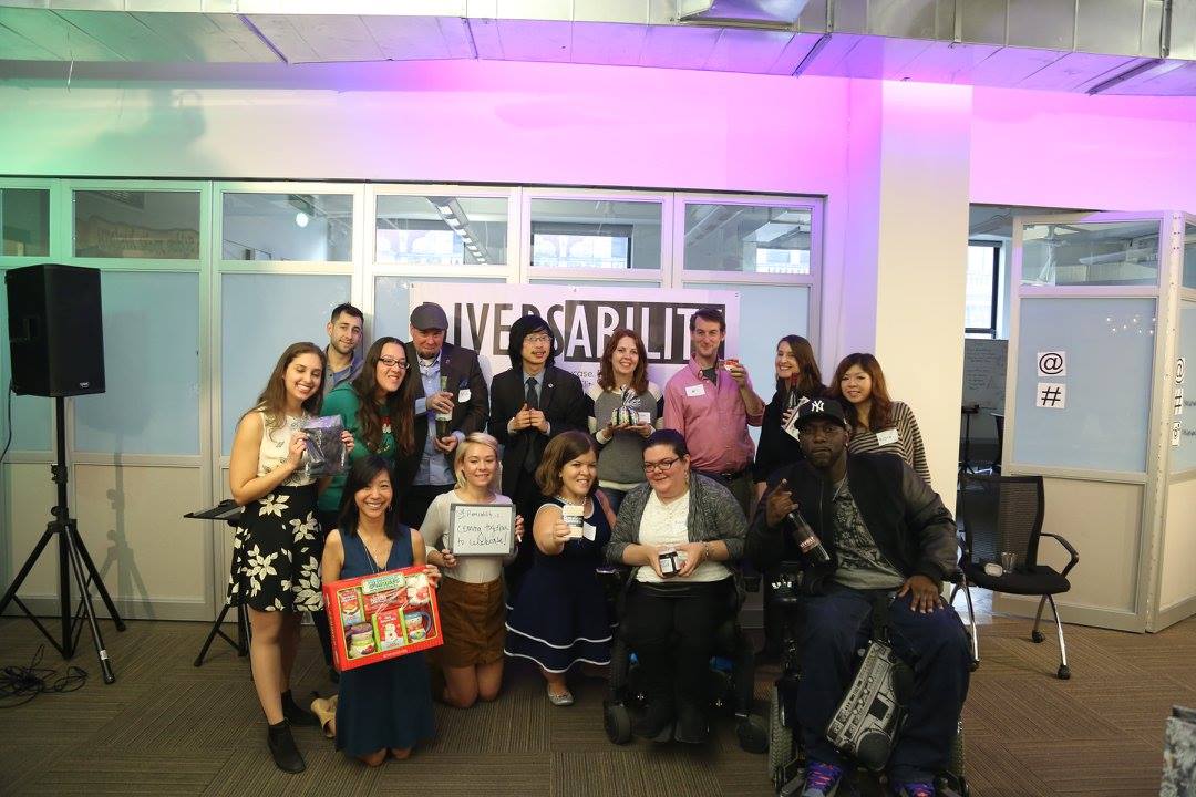 The Diversability community at a holiday gathering in 2015 with each person holding their gift.