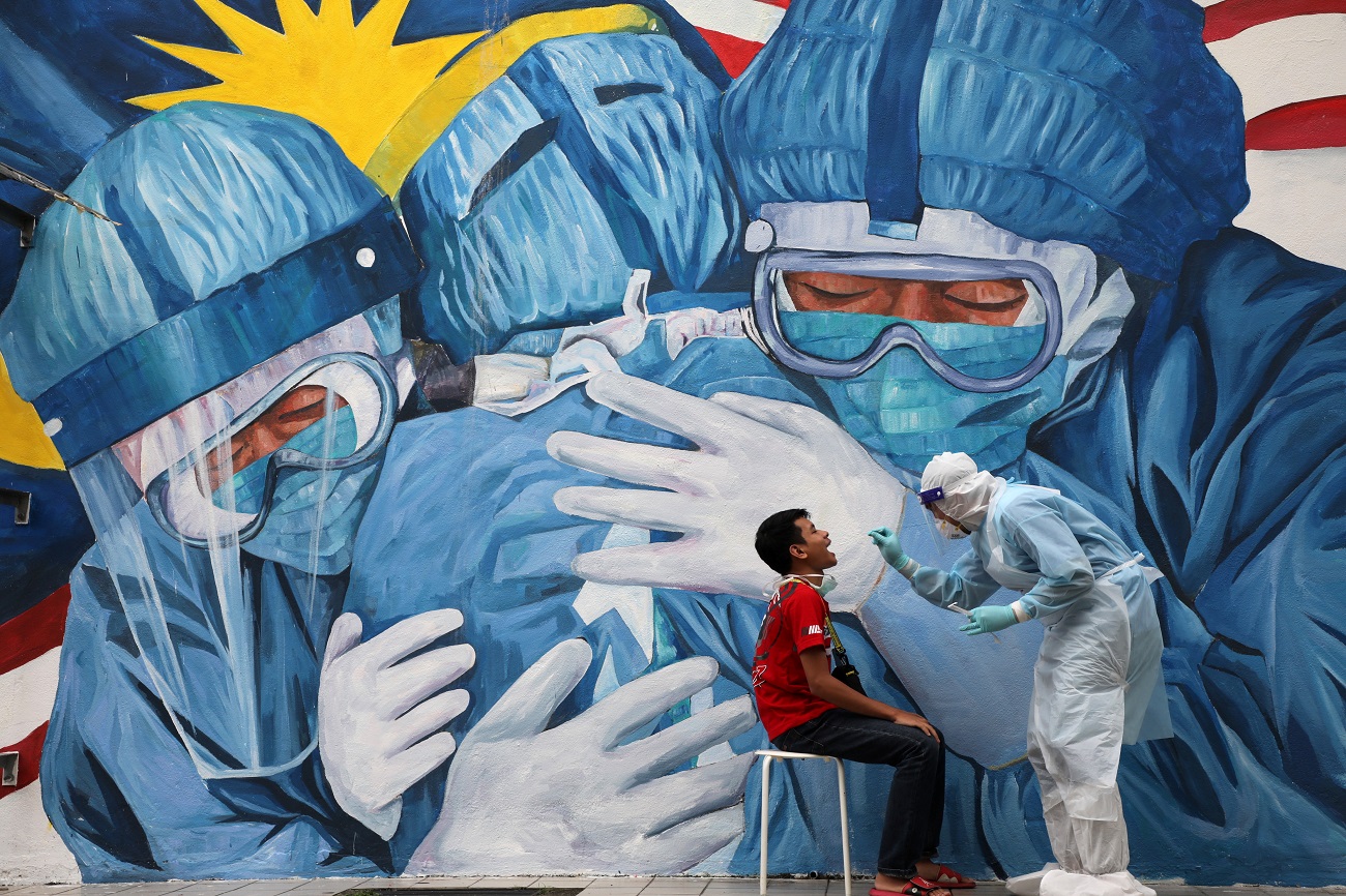 A doctor collects a swab sample from a man to be tested for the coronavirus disease (COVID-19) outside Clinic Ajwa in Shah Alam, Malaysia December 10, 2020. REUTERS/Lim Huey Teng TPX IMAGES OF THE DAY
