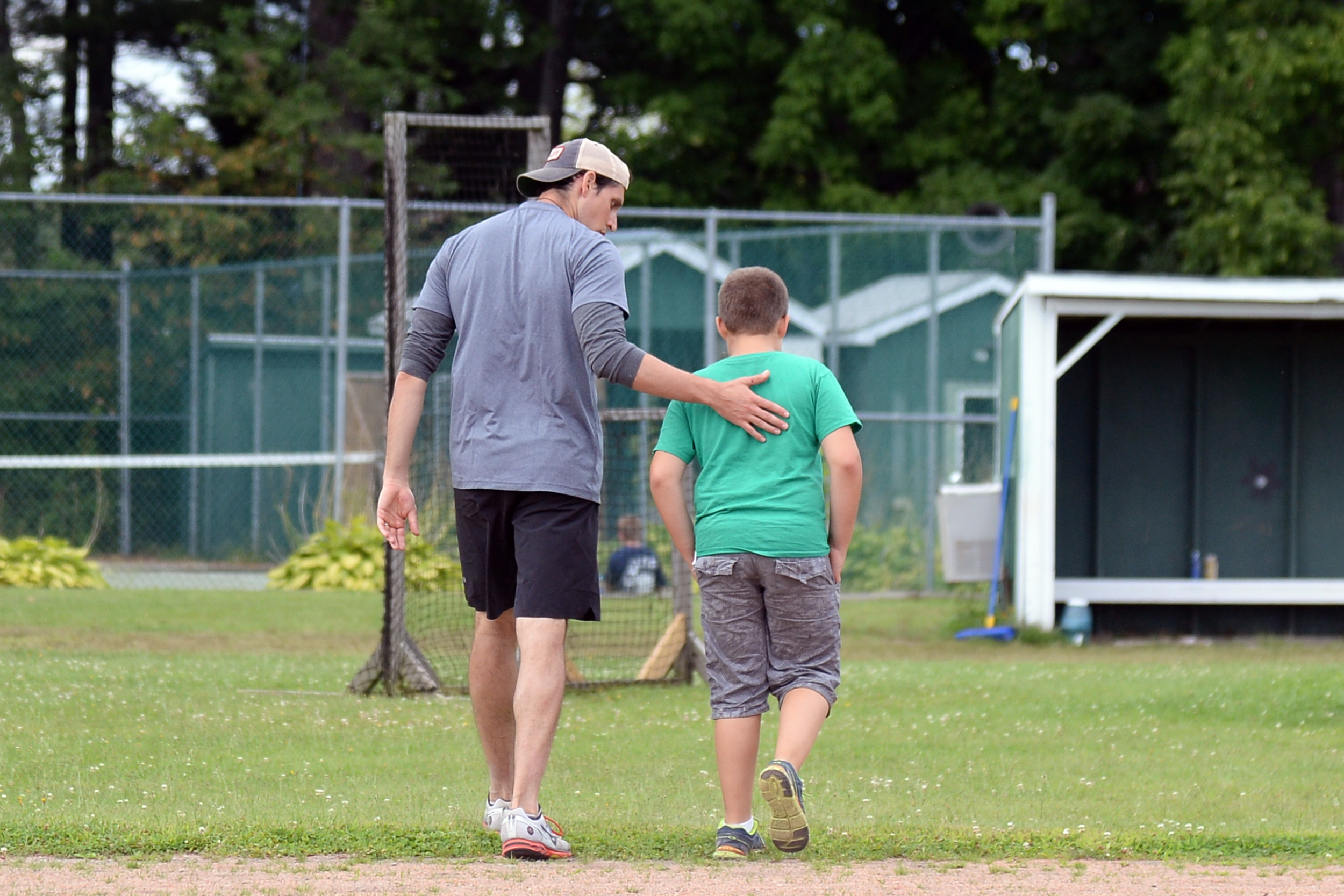 A volunteer consoling a grieving camper as they walk at Experience Camps.
