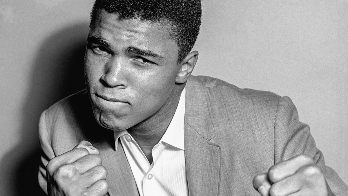 Muhammad Ali in a suit with fists up