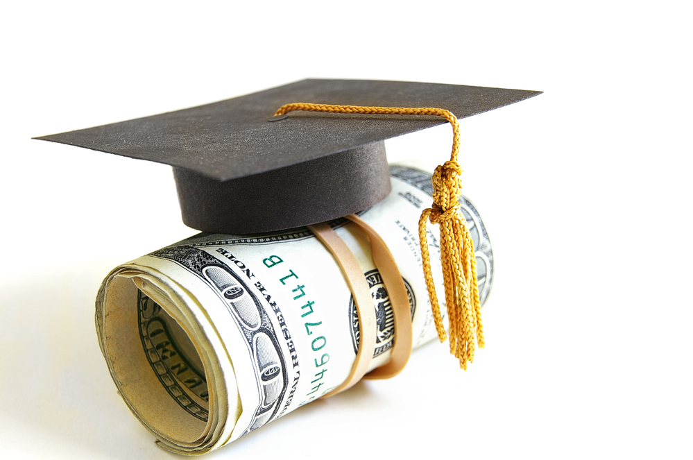 mini graduation cap on a roll of money