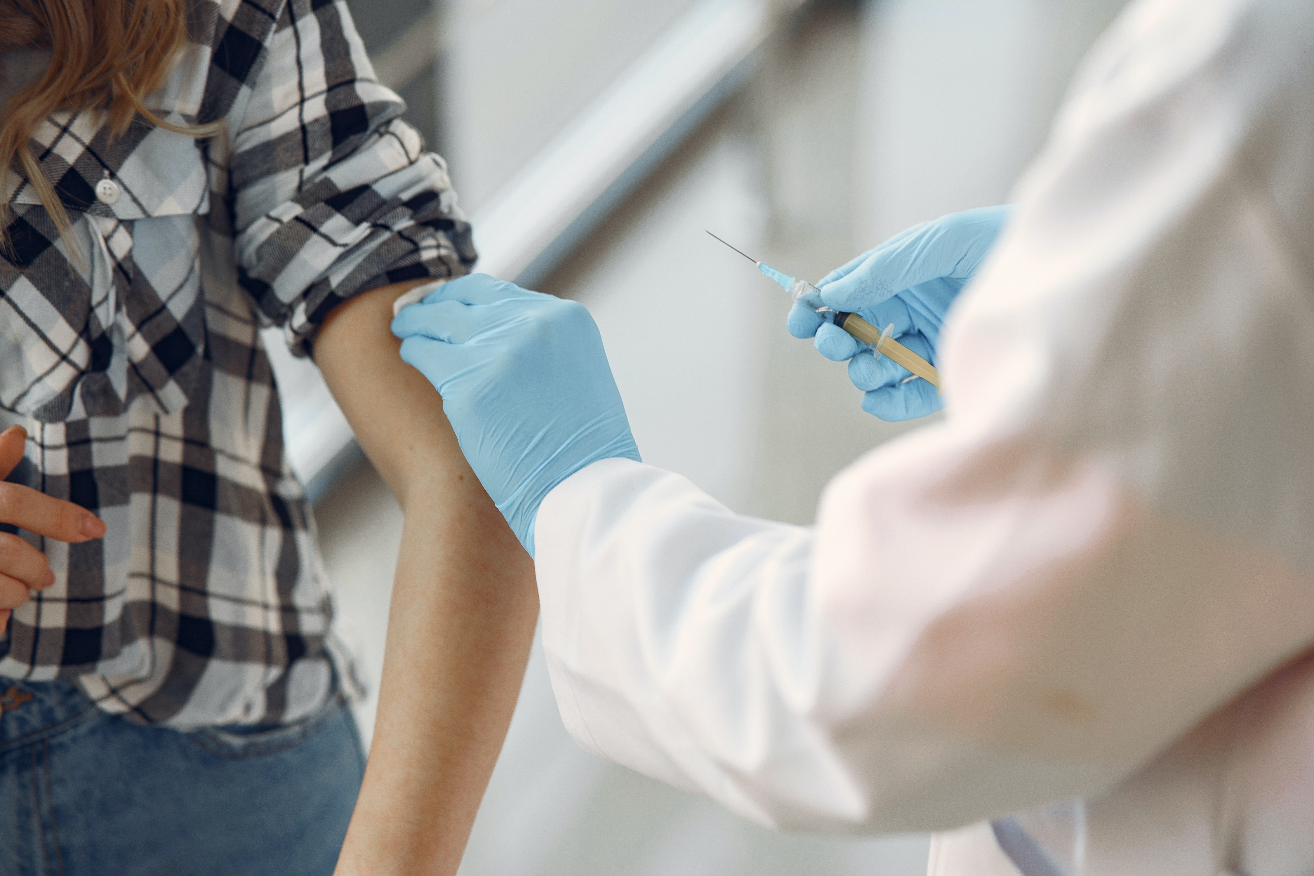 an image of a person getting a shot or vaccine, representing the COVID-19 vaccine