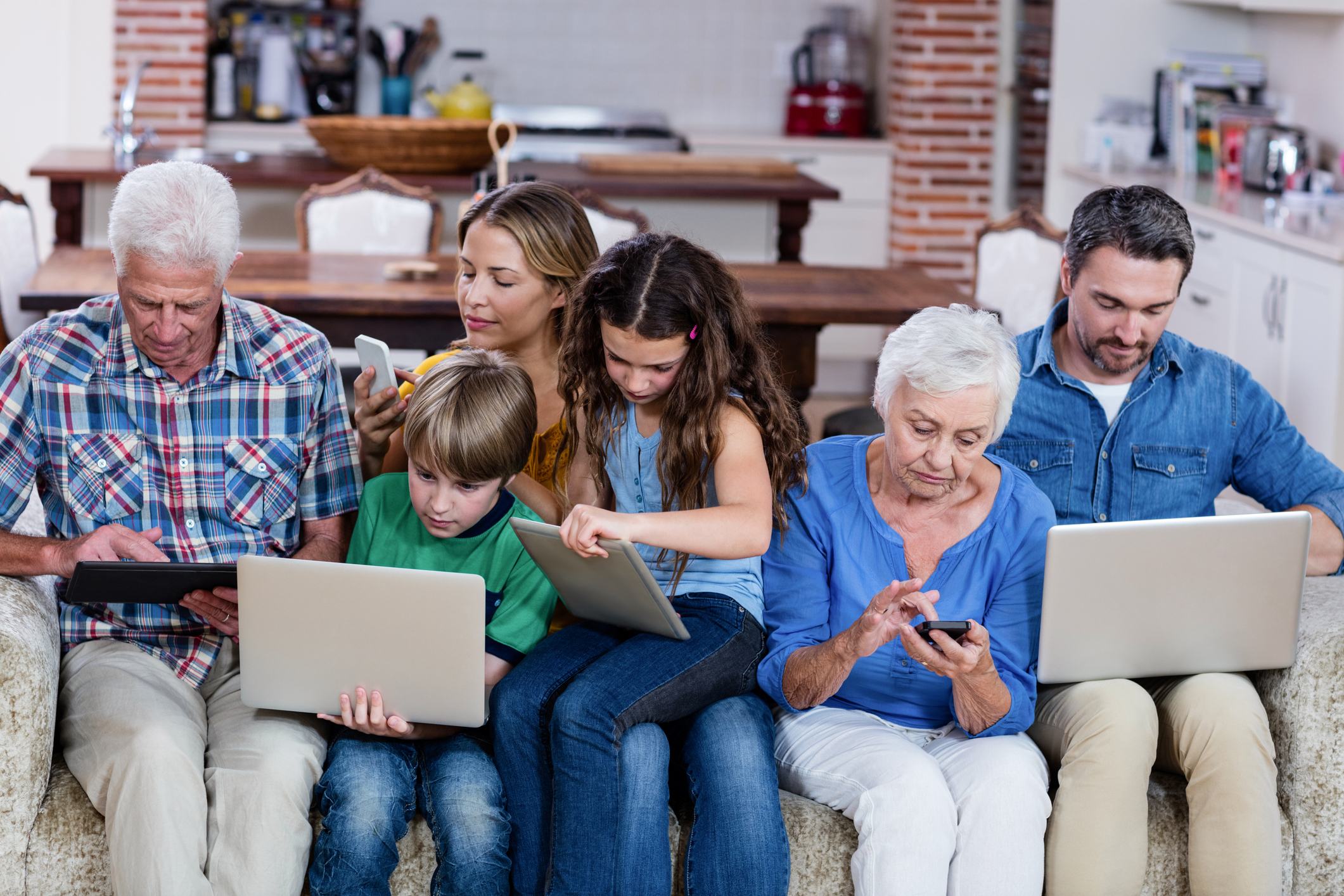 Multi-generation family using a laptop, tablet and phone at home
