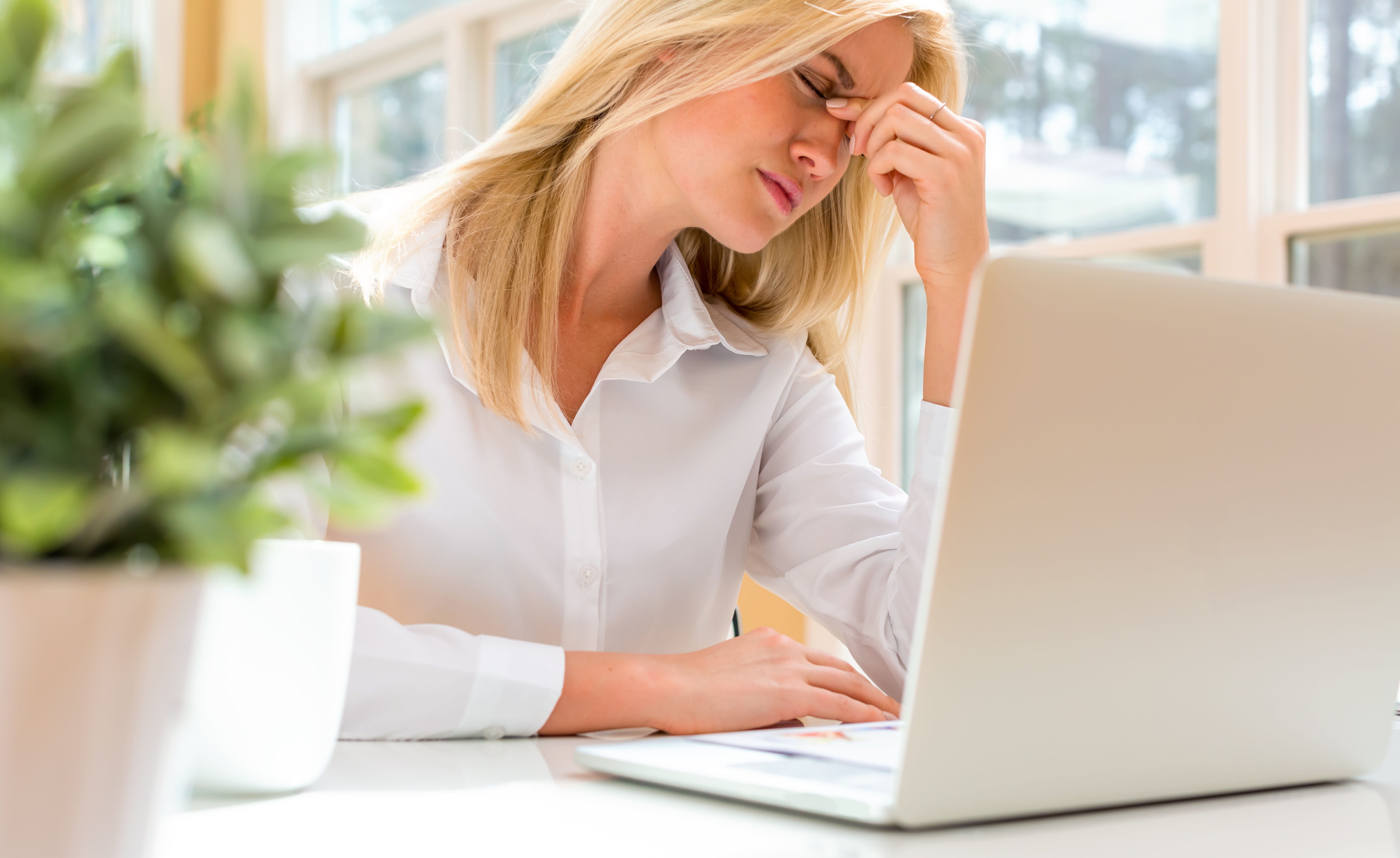 Young woman feeling stressed at her desk
