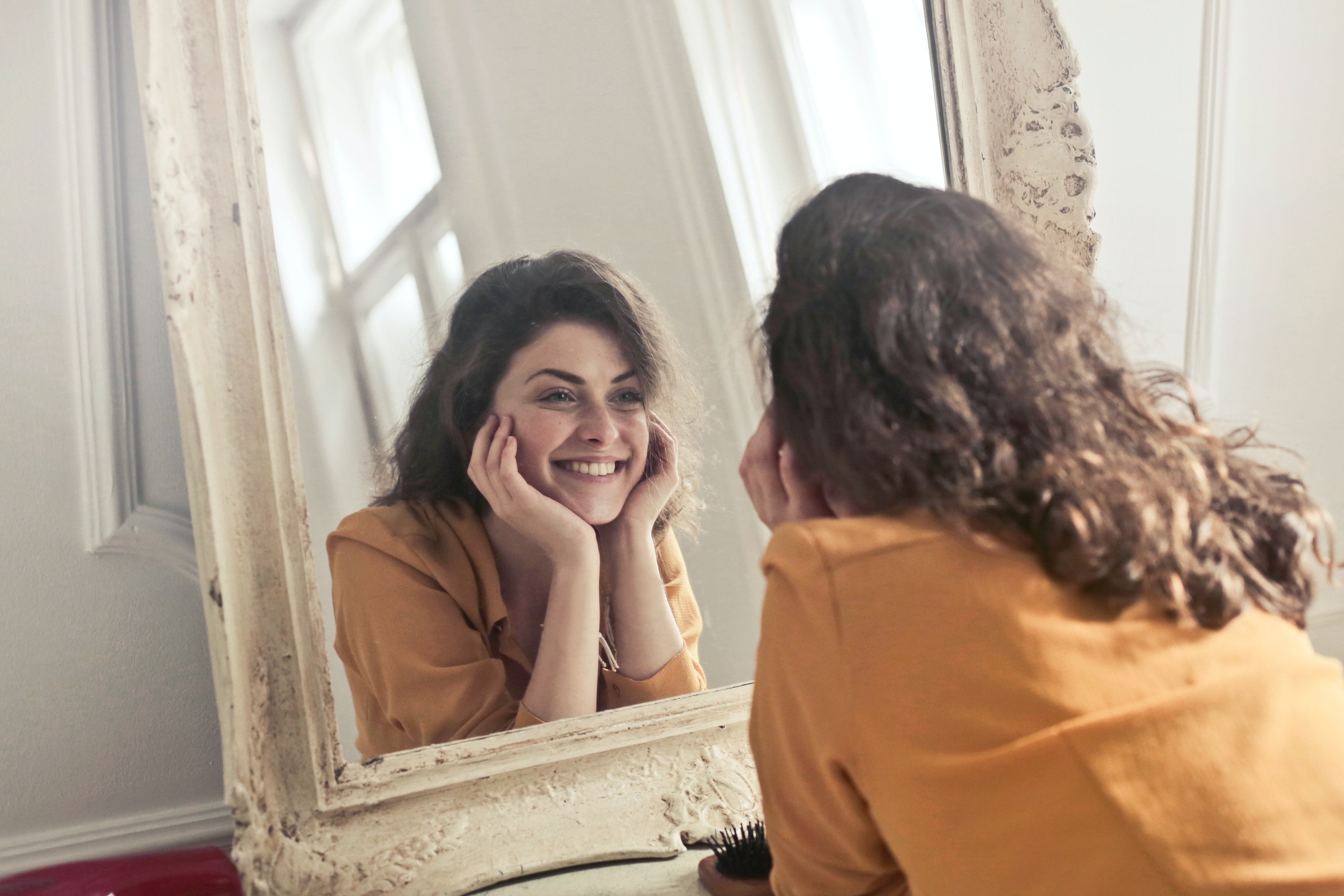 woman smiling looking into mirror