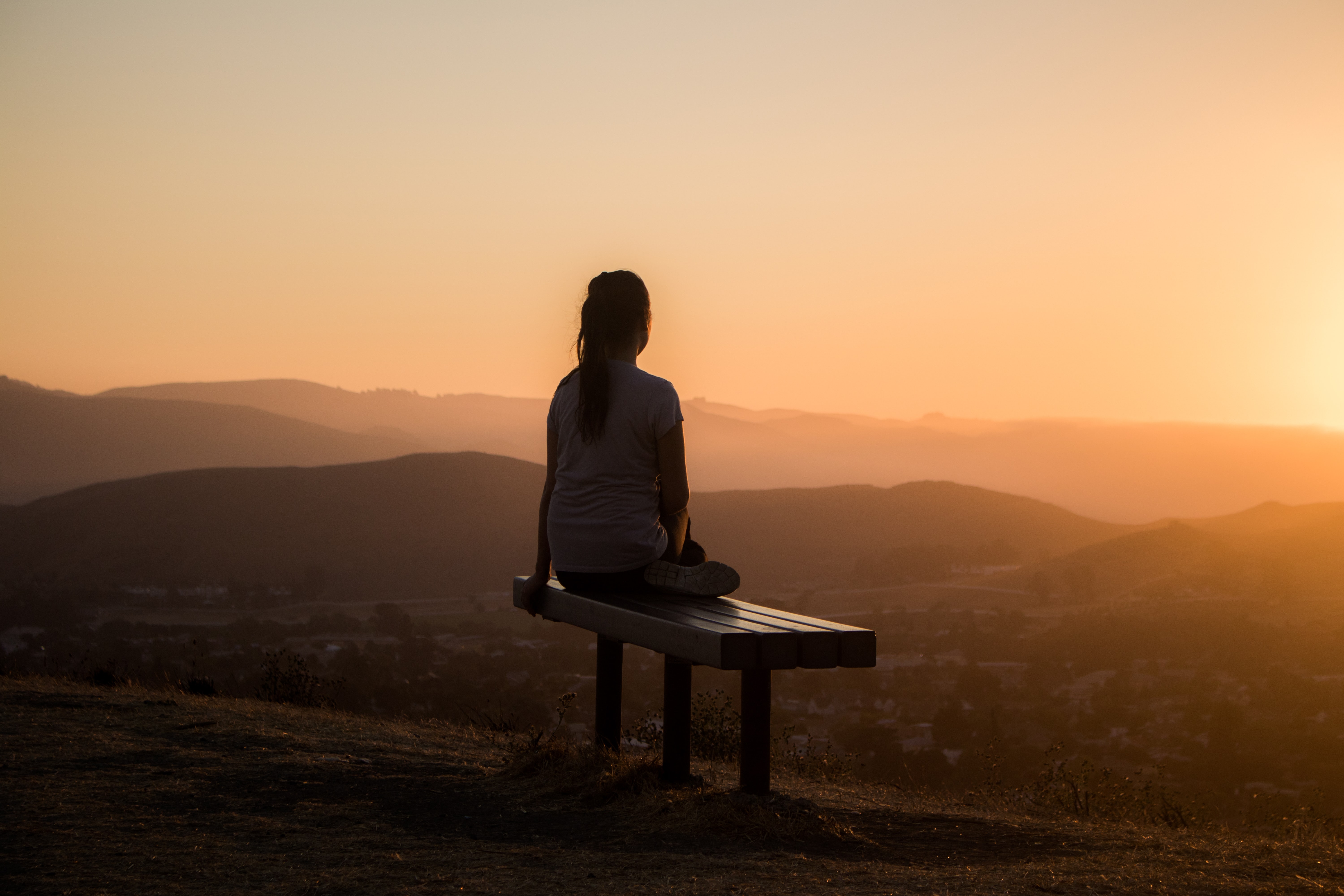 woman looking at the sunrise while meditating