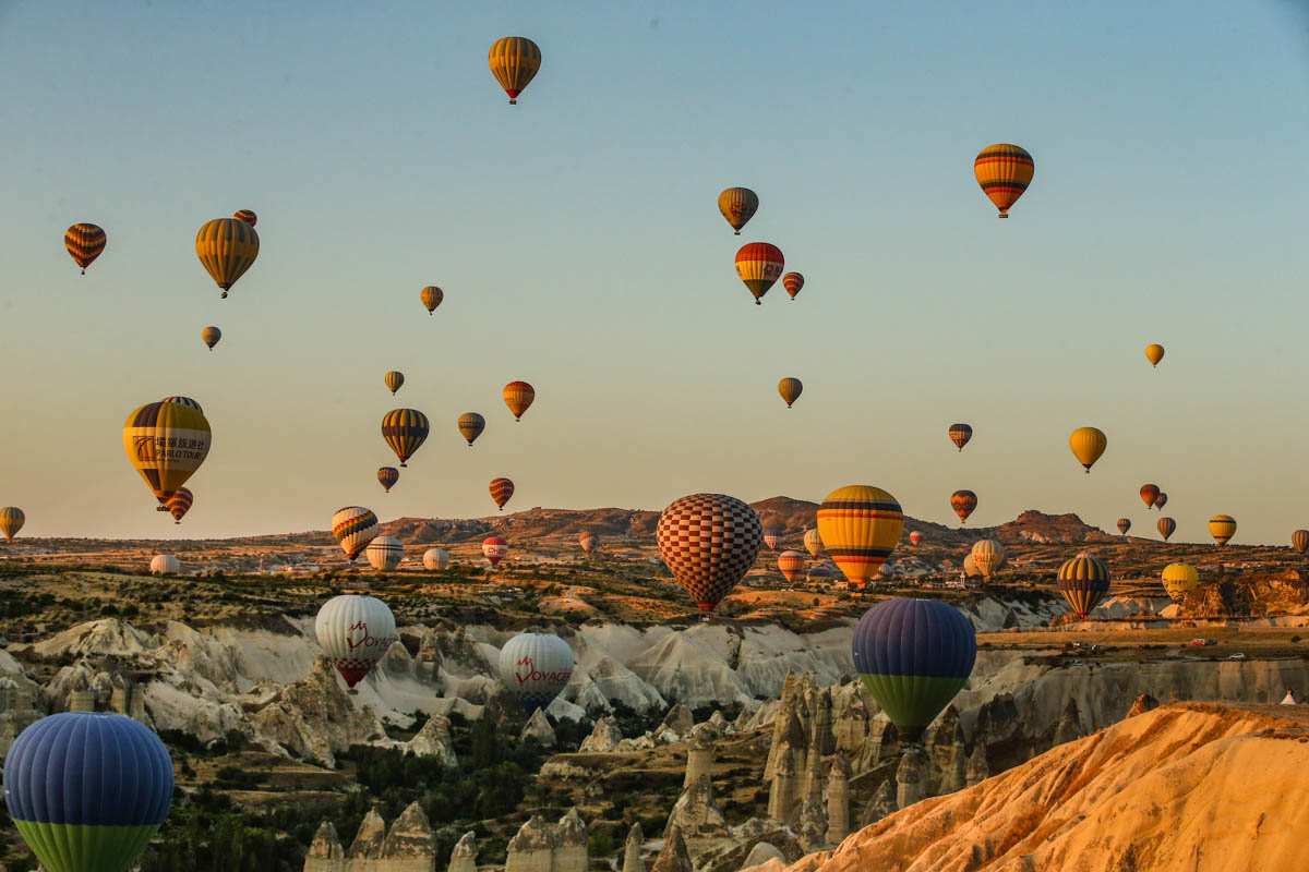 Hot air balloons, carrying tourists, rise into the sky at sunrise in Cappadocia, central Turkey, early Tuesday, Aug. 7, 2018.  Cappadocia has become a favourite site for tourists in hot-air balloons who can slowly drift above the cone-shaped rock formations and then float up over rippled ravines for breathtaking views over the region.(AP Photo/Emrah Gurel)