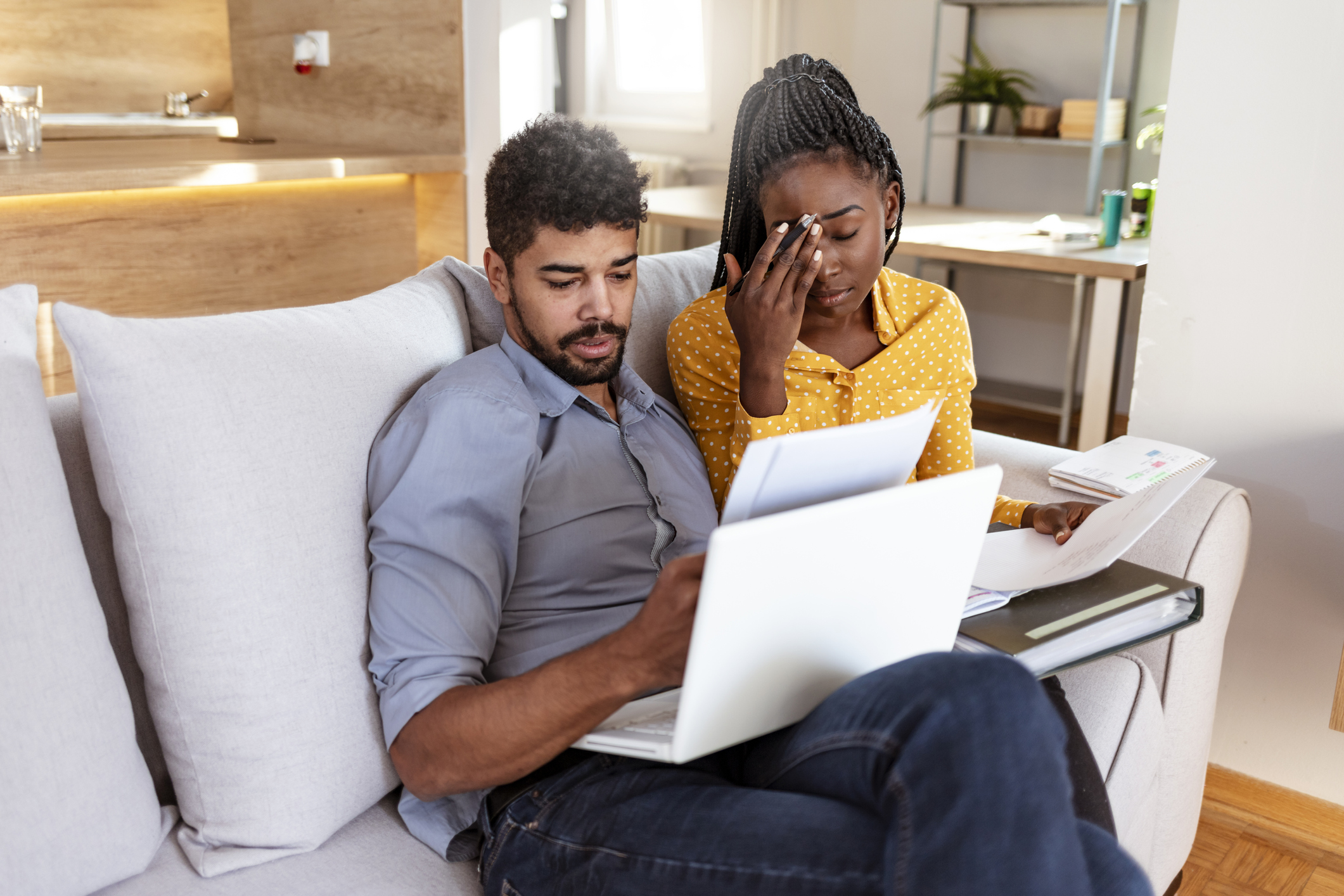 Young African American couple going over bills and doing online banking at home during the day.