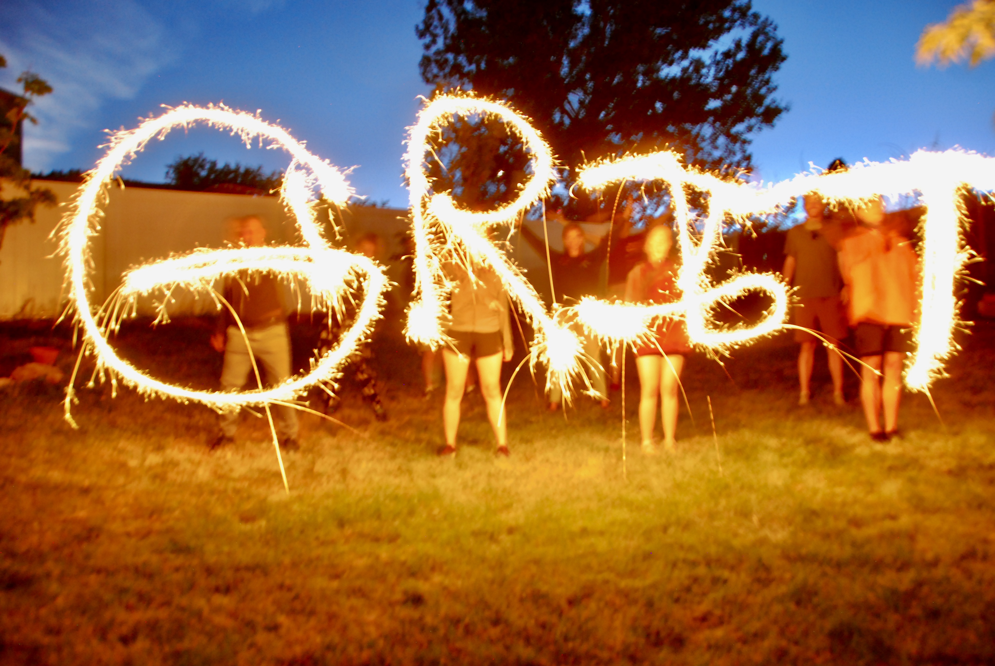 People holding sparklers spelling the word Grit