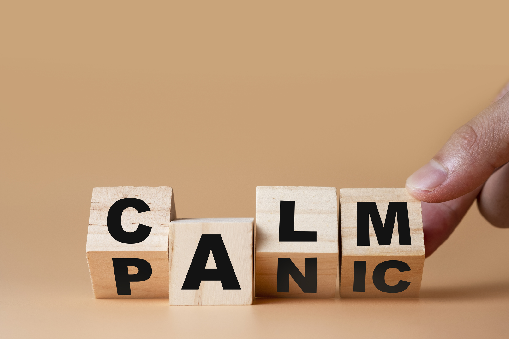 Hand flipping wooden cubes for change wording&quot; Panic &quot;  to &quot; Calm&quot;.  Mindset is important for human development.