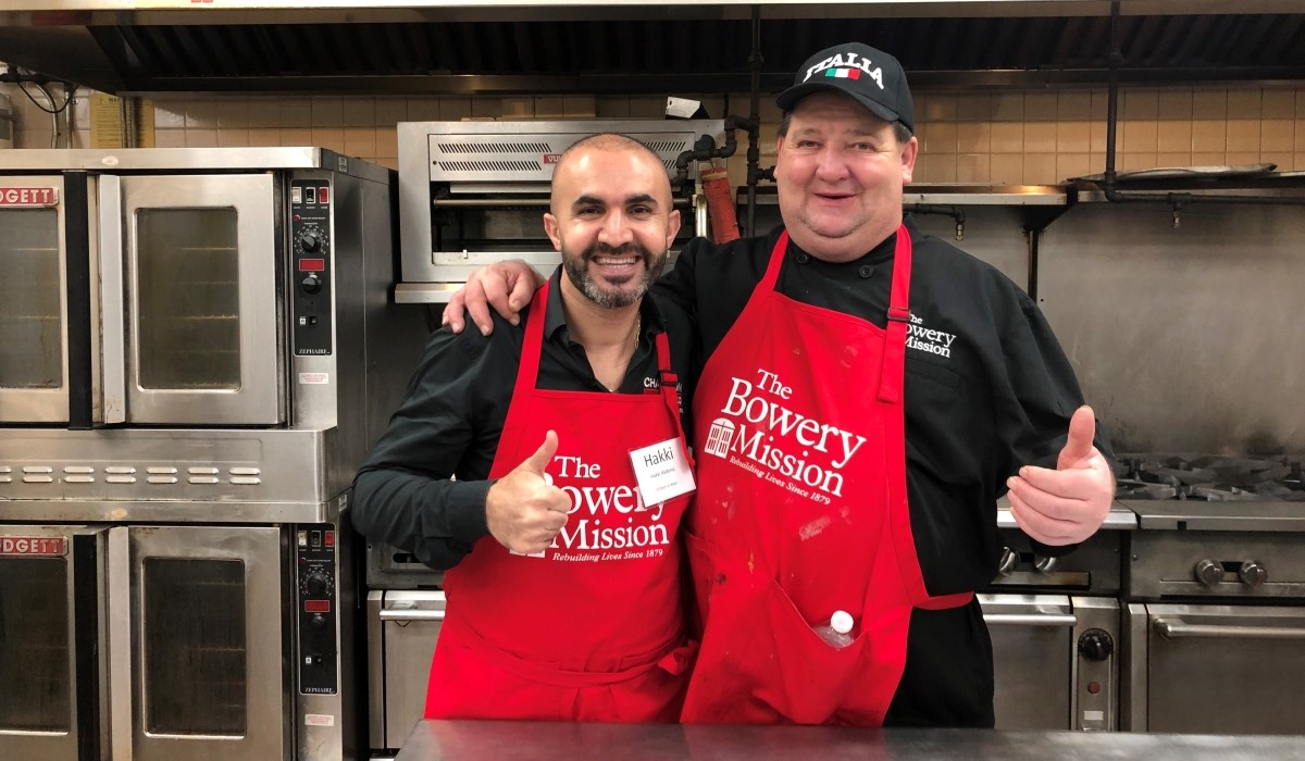 Hakki Akdeniz, left, helps serve the homeless population at the Bowery Mission, where he stayed for over three months when he himself was once homeless. /Courtesy Hakki Akdeniz