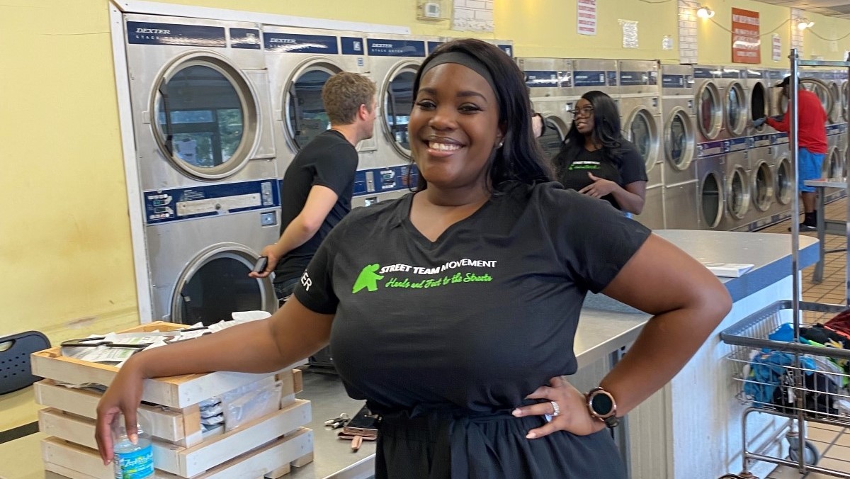 Woman stands smiling in a laundry room.