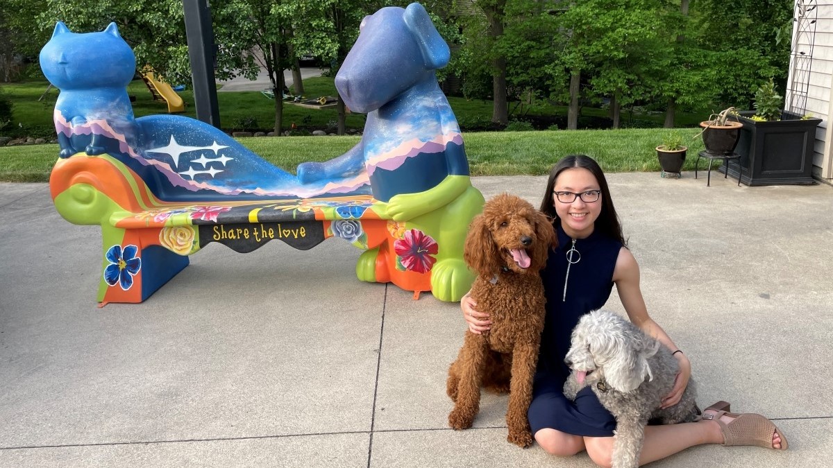 Madeline and her dogs in front of the artwork she painted for Humane Fort Wayne’s LoveSeats campaign, which raised over $120,000./Courtesy Madeline Phuong
