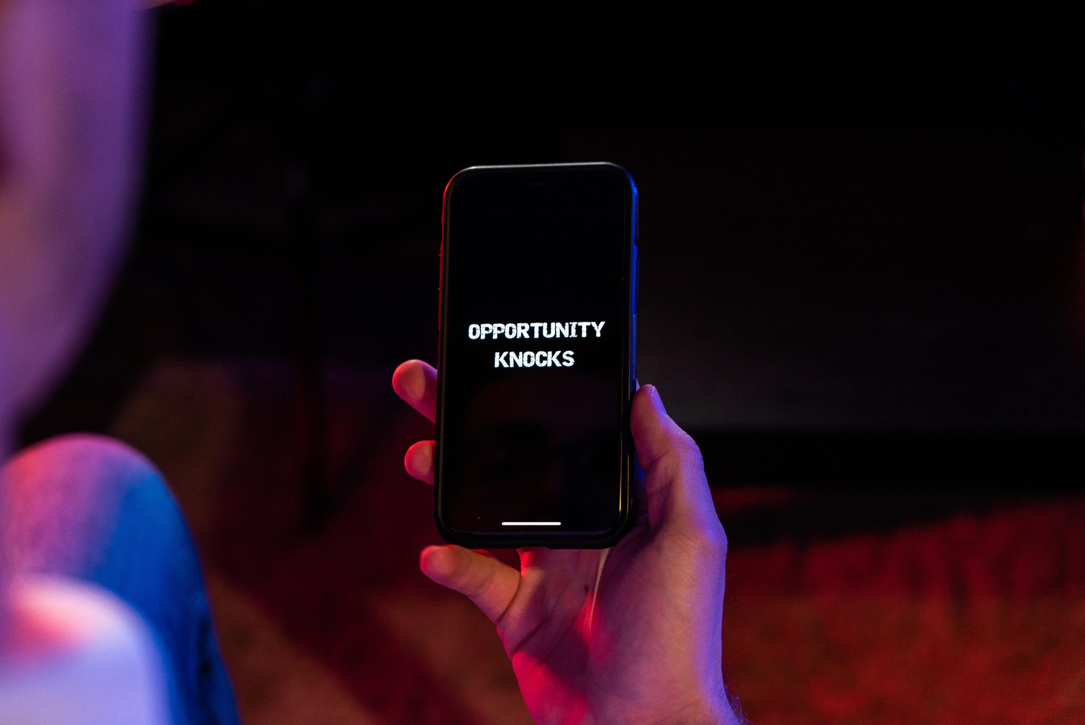 Opportunity knocks is written on a cellphone someone is holding
